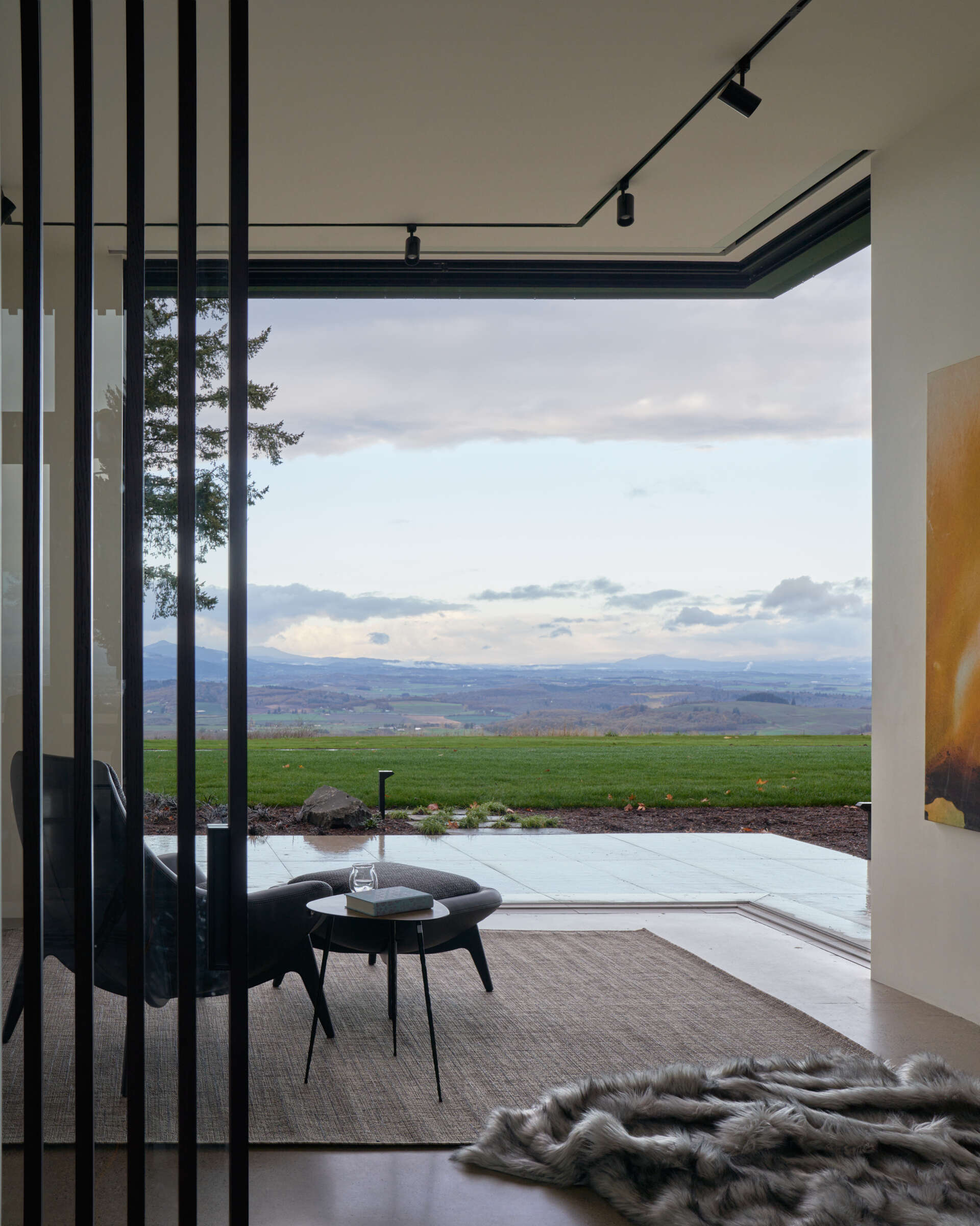 A modern room with glass doors that open the corner of the room.