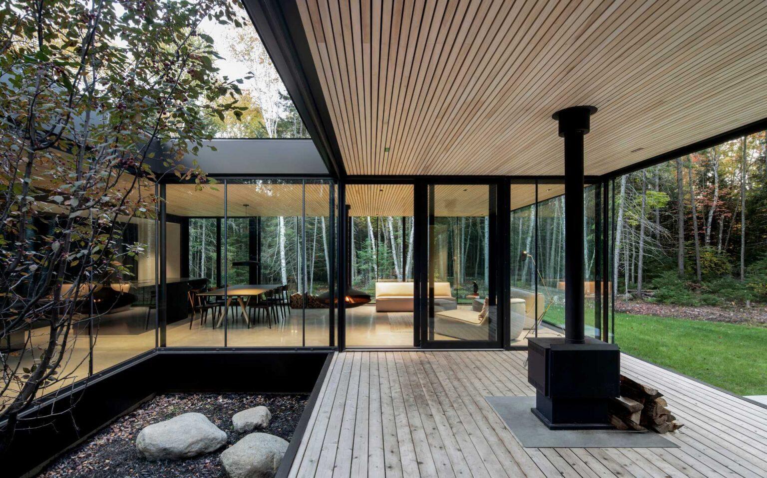 A sheltered porch extends from the living room, framing uninterrupted forest views while acting as a protected outdoor space.