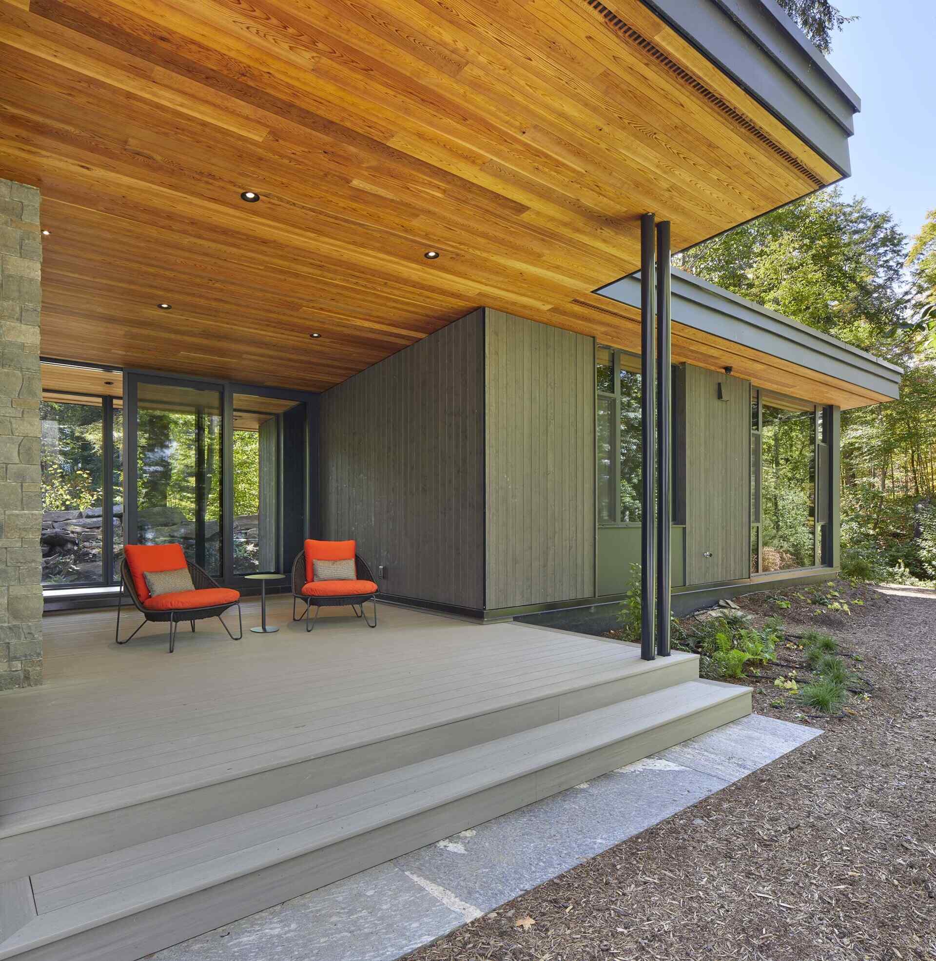 The primary bedroom wing is separated from the rest of the cottage by a glazed walkway. This connection creates a transition between the central great room and the private sleeping wing while maintaining visual continuity through the structure.