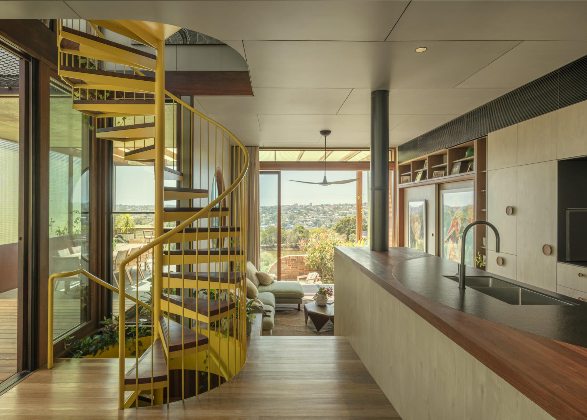 This contemporary kitchen combines a recycled hardwood island, walk-in pantry, harbour views, and custom timber detailing perfect for family gatherings.