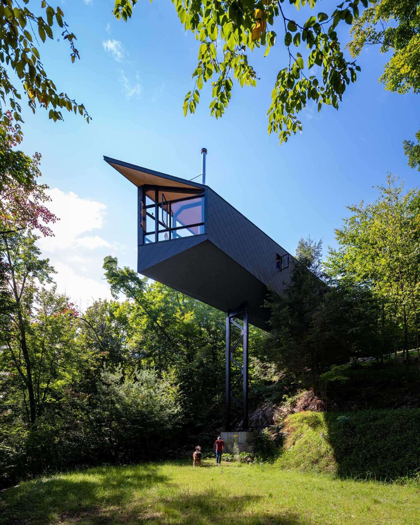 A steel mast and minimal foundation give this modern cabin its floating appearance while helping preserve the forest below.