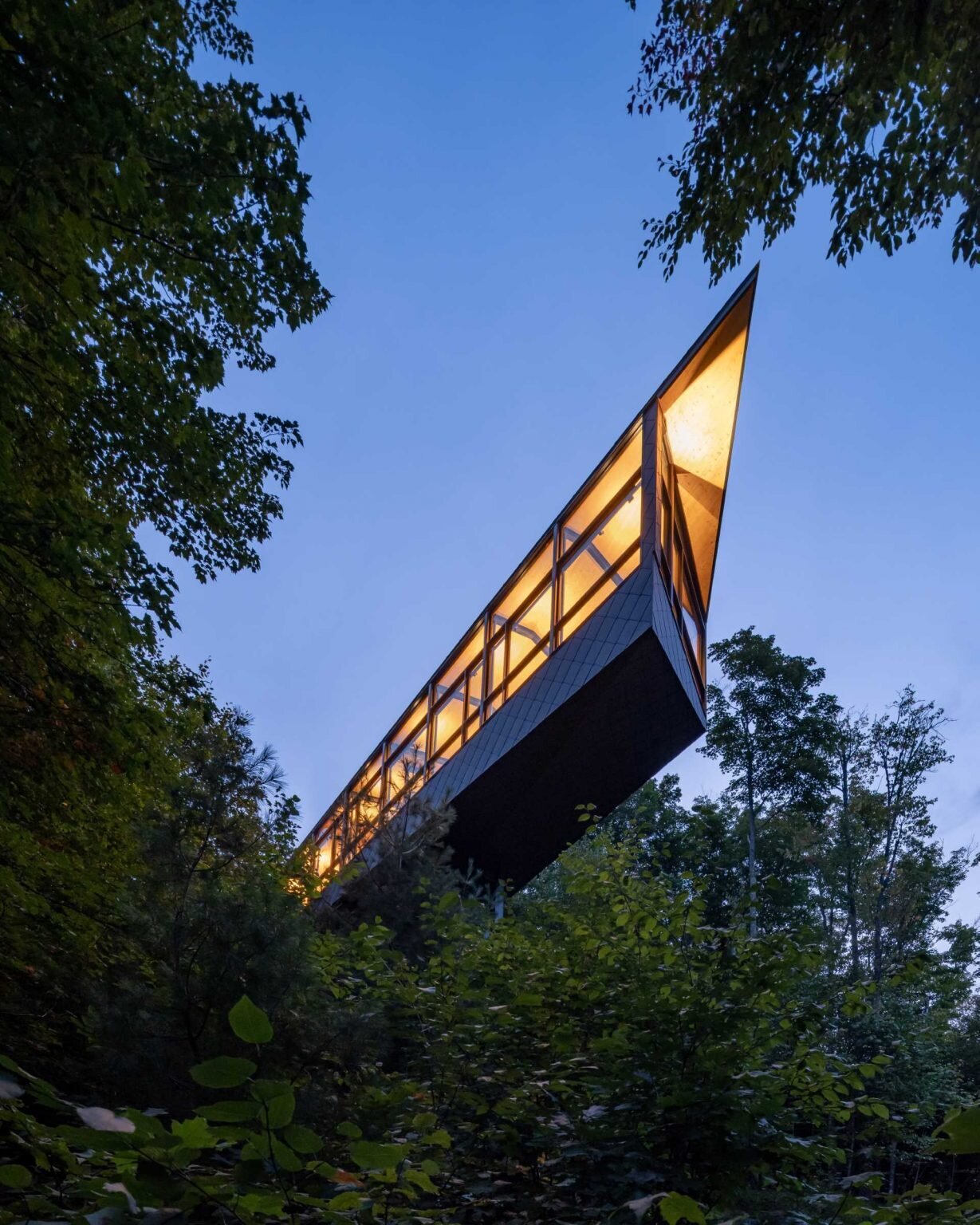 A steel mast and minimal foundation give this modern cabin its floating appearance while helping preserve the forest below.