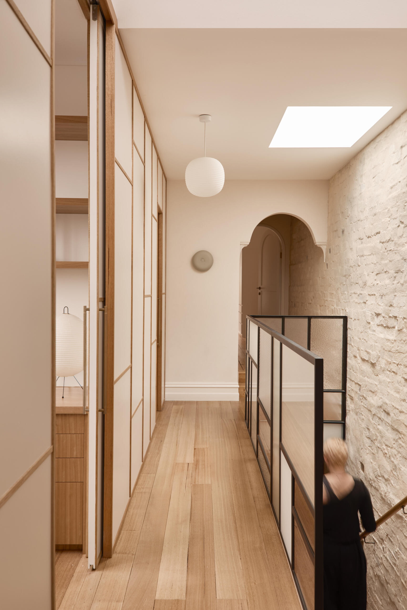 An upstairs hallway with shoji-style partitions concealing a study, blending Japanese influence with Victorian terrace structure.