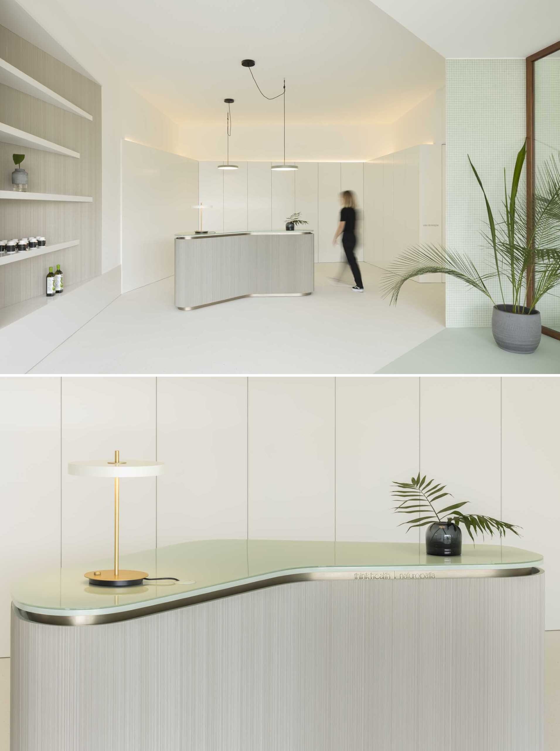 This minimalist reception area uses curved forms, soft colors, and subtle floor details to separate spaces without interrupting the open layout.