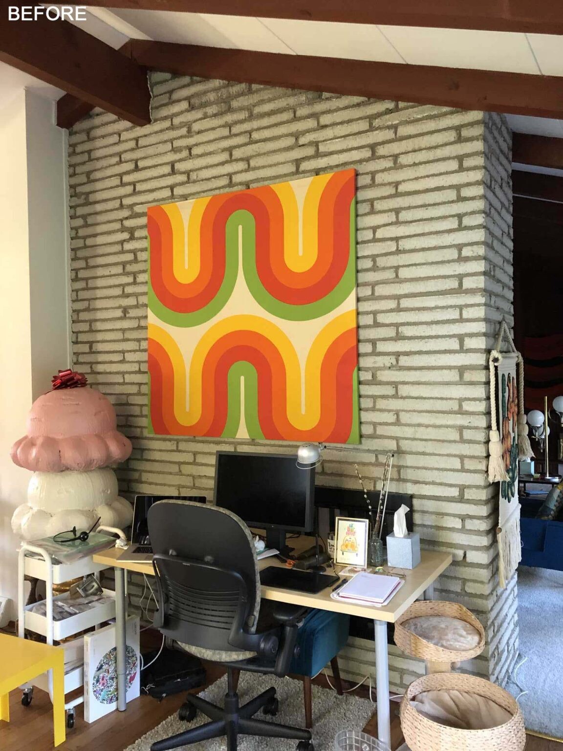BEFORE - A preserved double-sided fireplace anchors this bright living room, where large windows, simple furnishings, and views of the patio help celebrate the home's mid-century architecture.