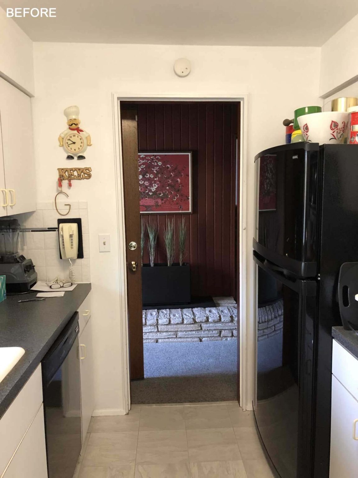 BEFORE - This open-concept kitchen replaces a once closed-off layout with white countertops, wood cabinetry, a window-side bar area, and seamless connections to the dining and living spaces.
