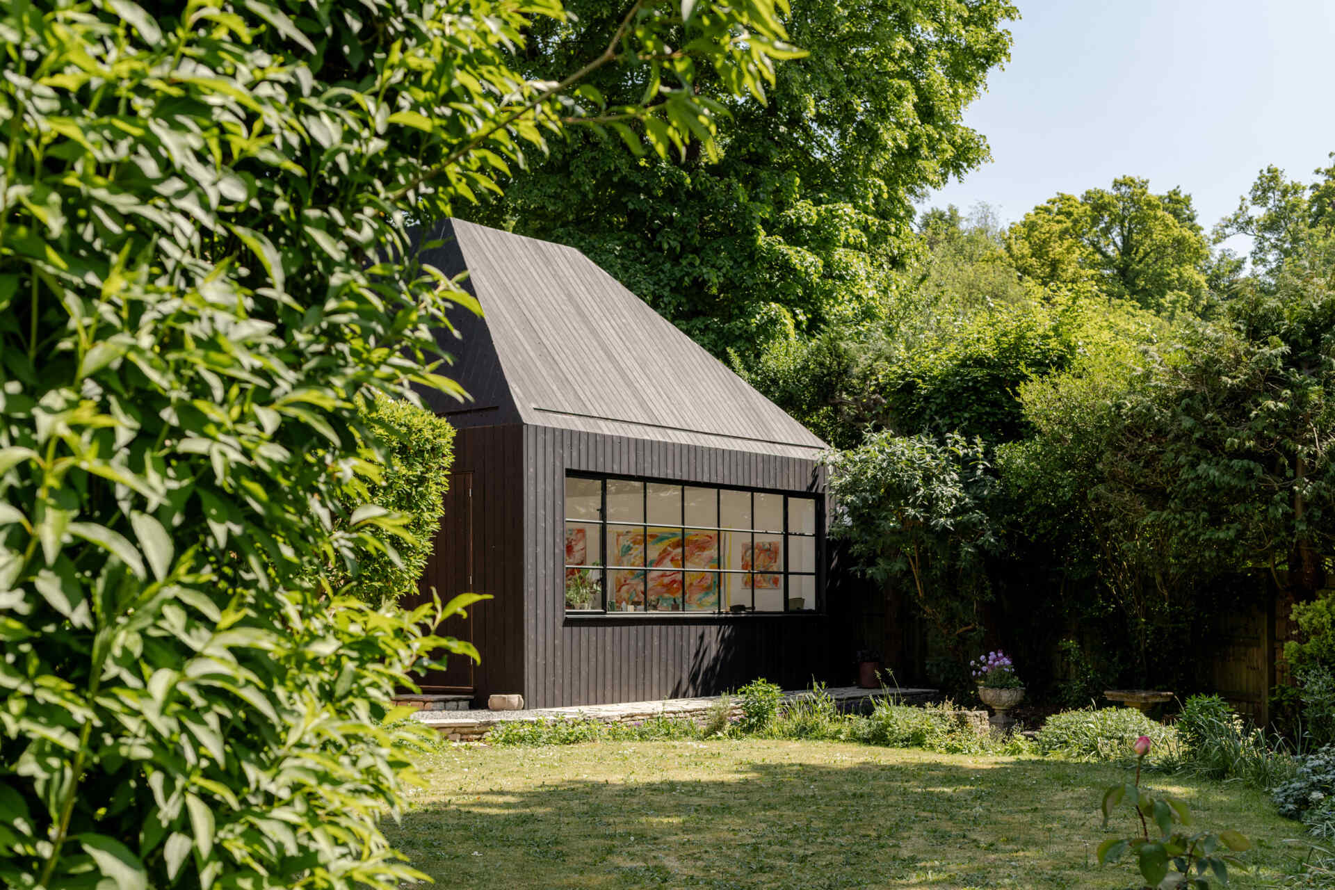 Hidden within a garden near Salisbury, this art studio features charred timber cladding, high-performance SIP construction, natural daylight, and low-impact foundations.