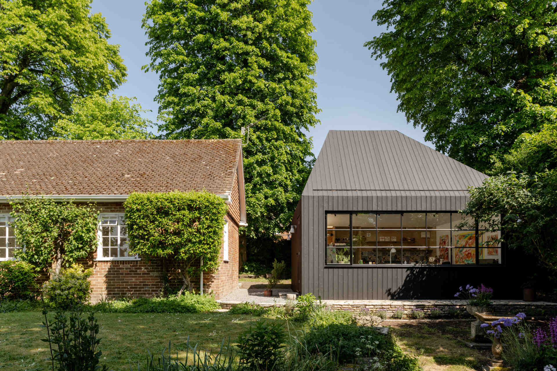 Hidden within a garden near Salisbury, this art studio features charred timber cladding, high-performance SIP construction, natural daylight, and low-impact foundations.