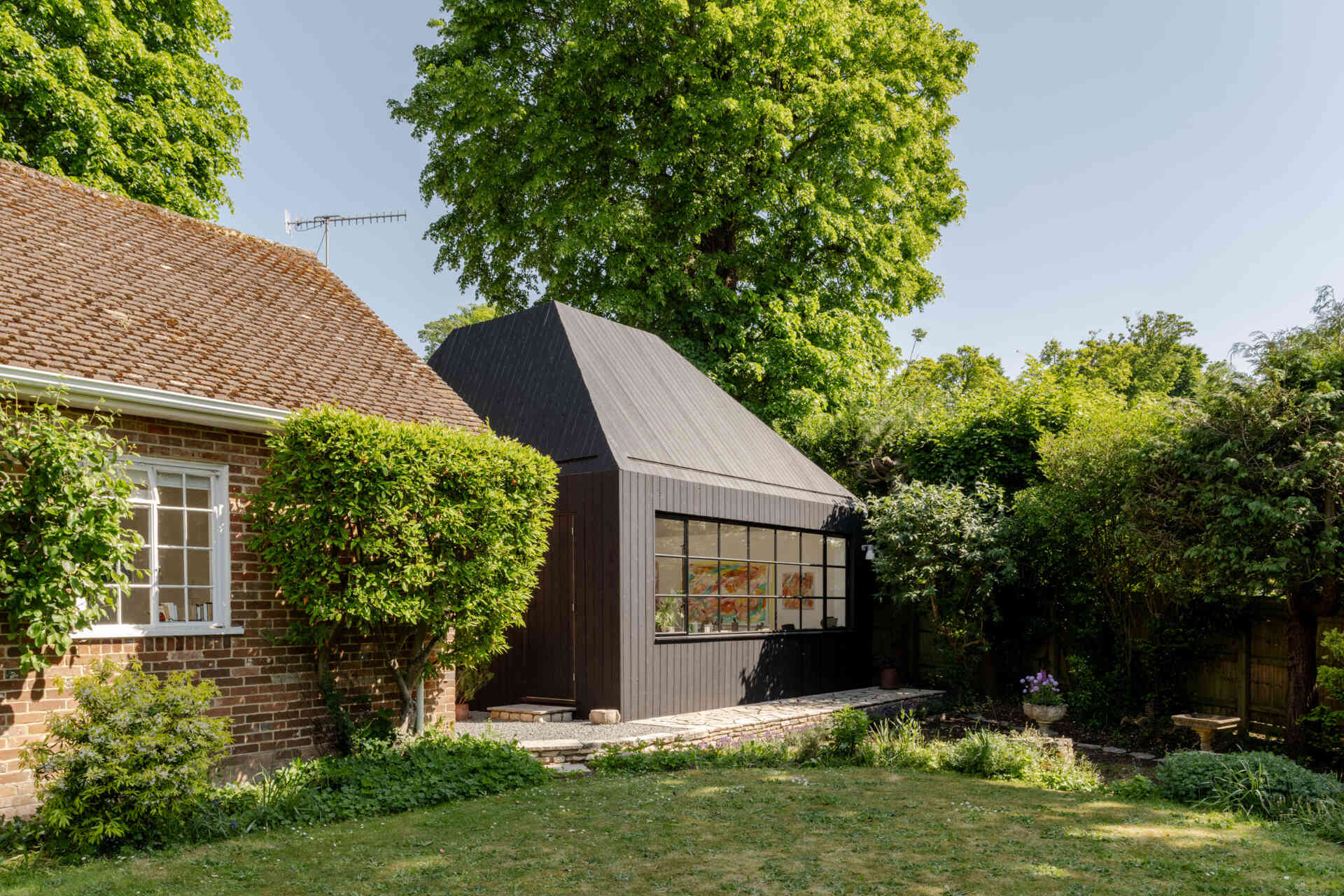 Hidden within a garden near Salisbury, this art studio features charred timber cladding, high-performance SIP construction, natural daylight, and low-impact foundations.