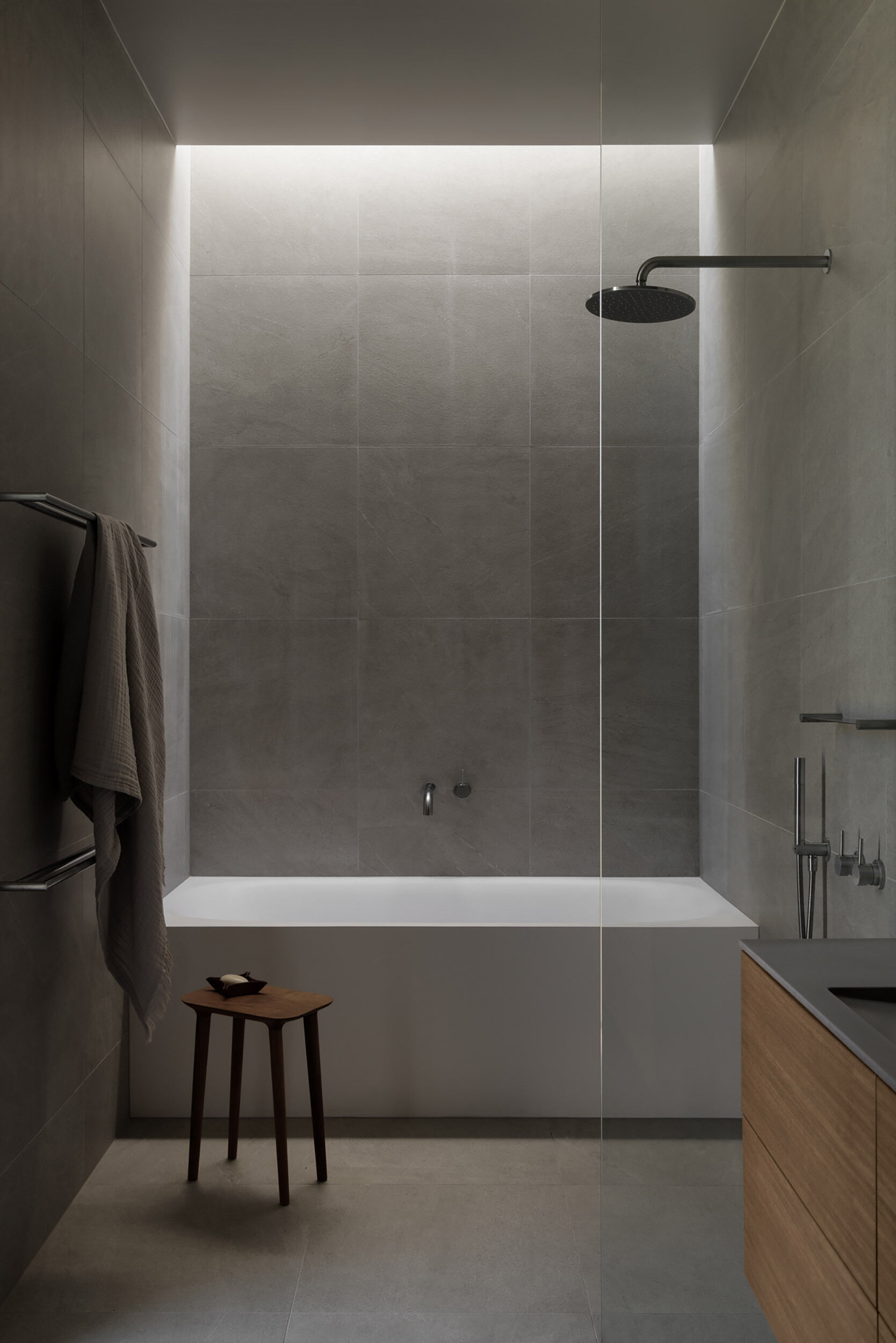 Simple materials, clean lines, and a neutral palette create a guest bathroom that complements the home's understated aesthetic.