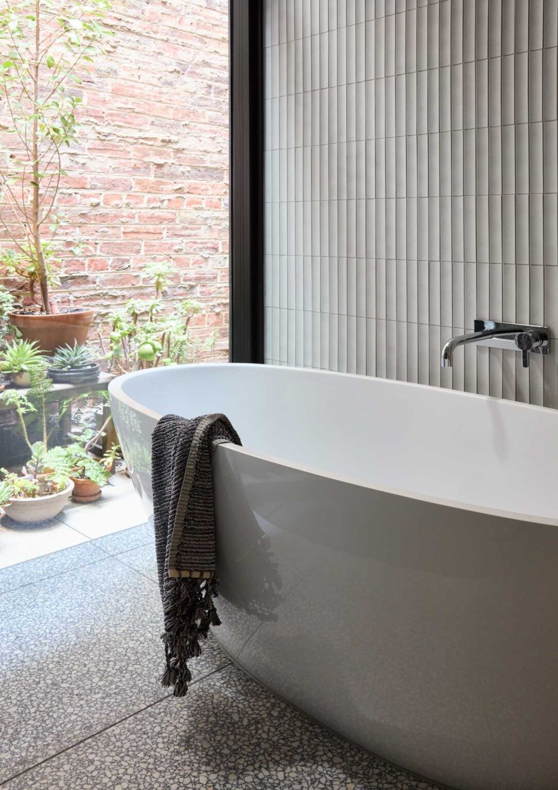 A floating timber vanity, freestanding bathtub and walk-in shower give this contemporary bathroom a warm and elegant feel.