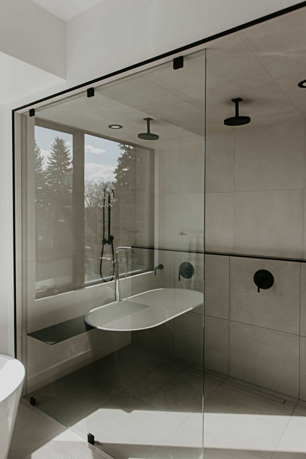 Arched mirrors, black vanities, terrazzo tile, and a freestanding tub create a bathroom full of elegant modern inspiration.