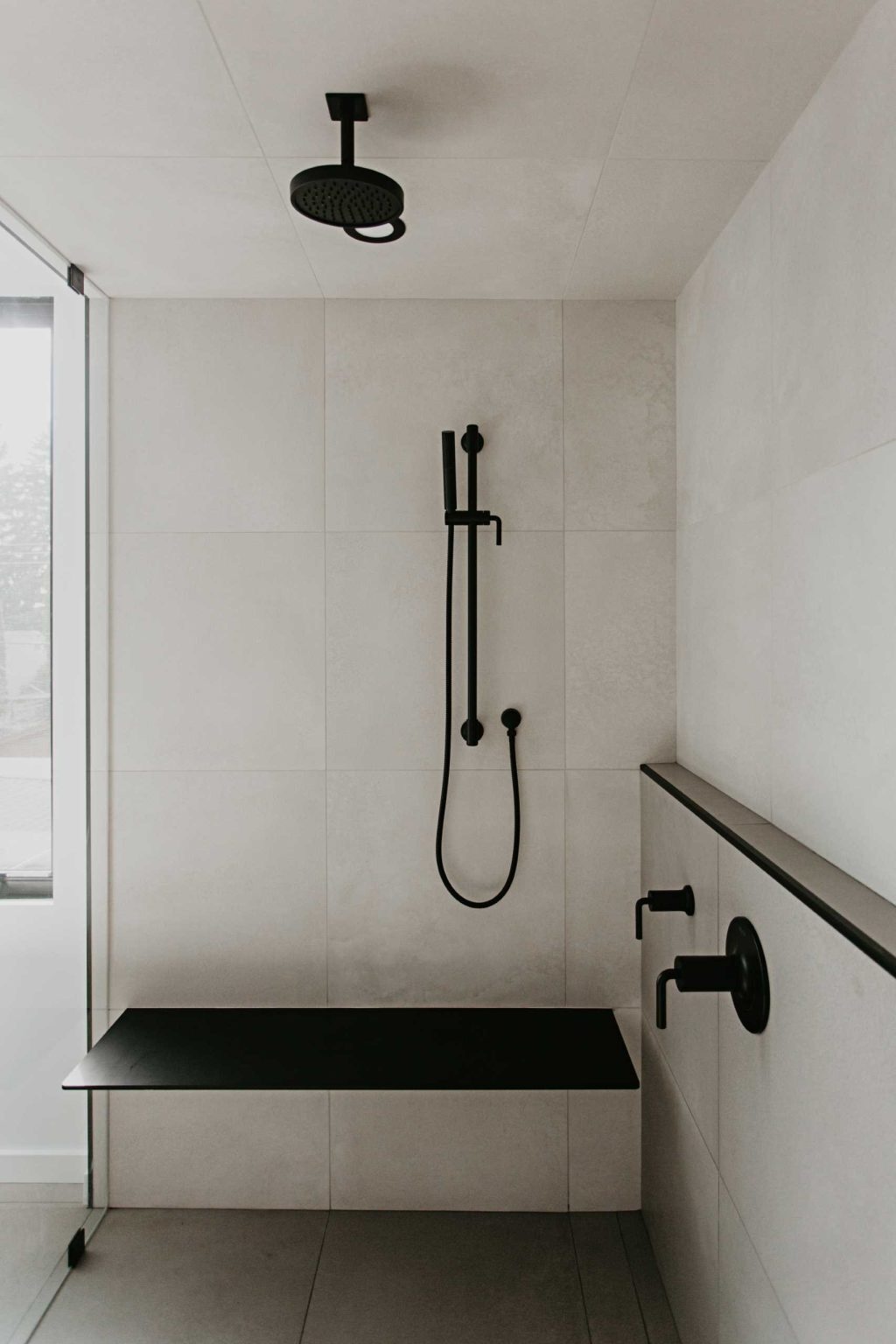 Arched mirrors, black vanities, terrazzo tile, and a freestanding tub create a bathroom full of elegant modern inspiration.