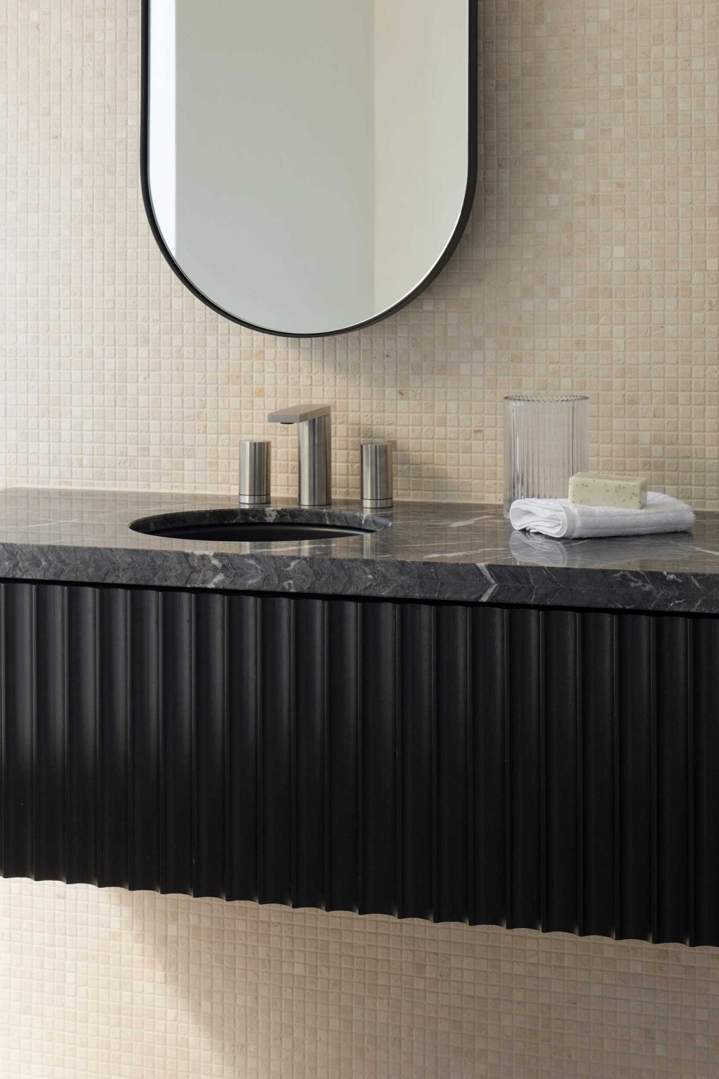 Travertine mosaic walls, stained timber, and stone vanities bring texture and sophistication to the bathrooms at No. 6 Sydney Street.