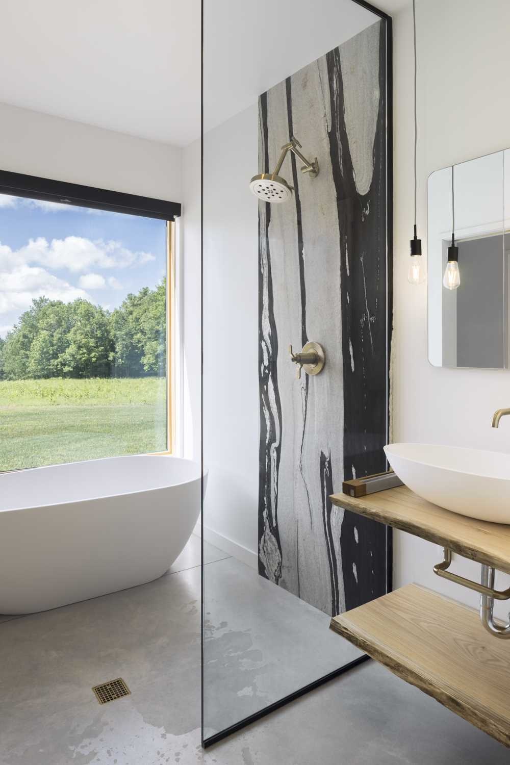 Natural oak, brass fixtures, and uninterrupted countryside views give this bathroom a calm and distinctive character.