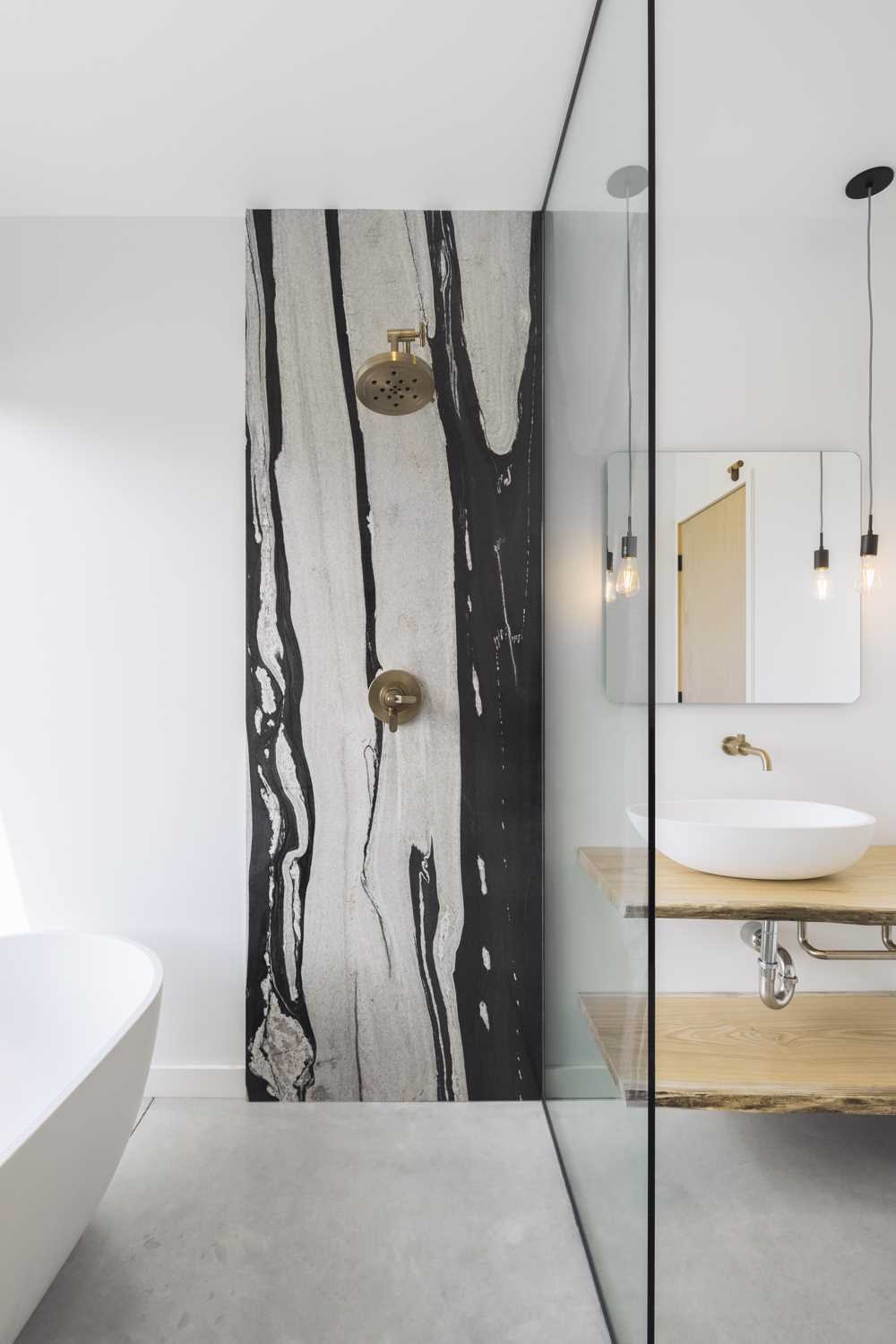 Natural oak, brass fixtures, and uninterrupted countryside views give this bathroom a calm and distinctive character.
