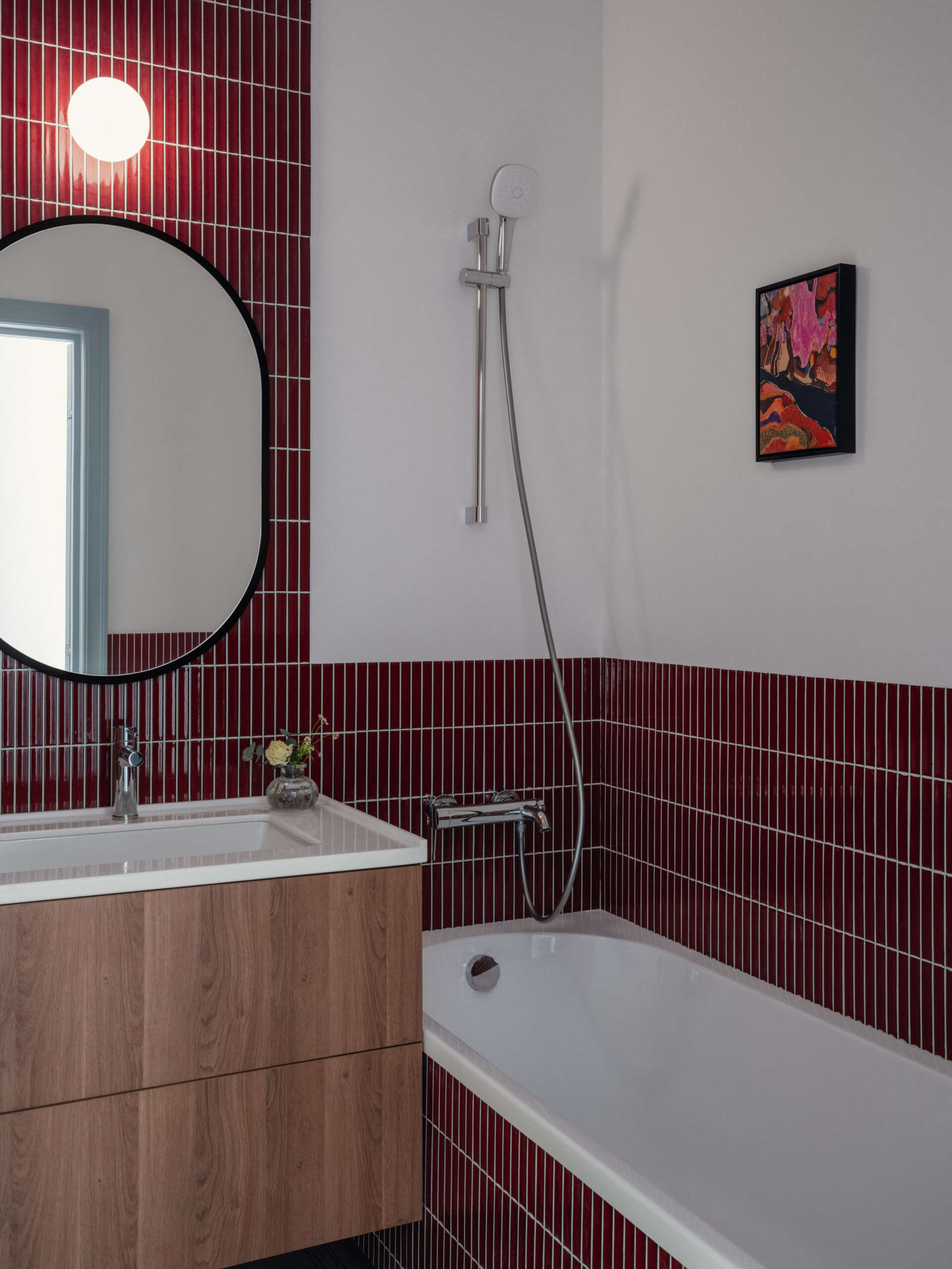 Bold red tiles bring personality and warmth to the main bathroom, creating one of the most memorable design features in the apartment.