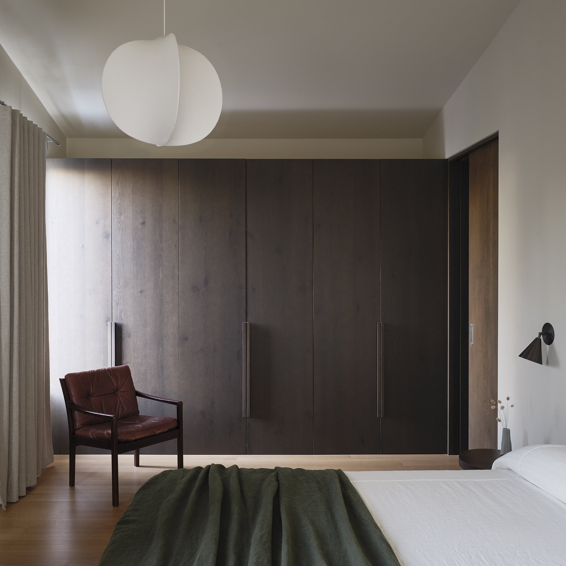 This modern bedroom includes simple finishes, generous daylight, and plenty of storage, allowing the space to feel larger than its footprint suggests.
