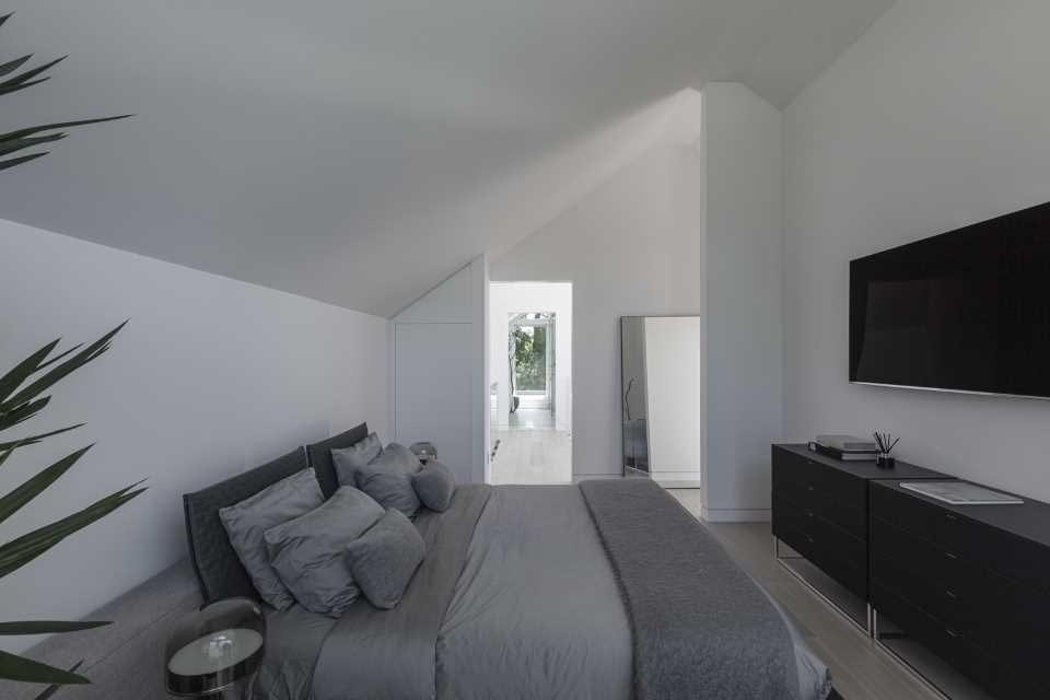 Located in the uppermost volume, this bedroom includes a spacious walk-through closet and enjoys a sense of privacy within the home's unique stacked design.
