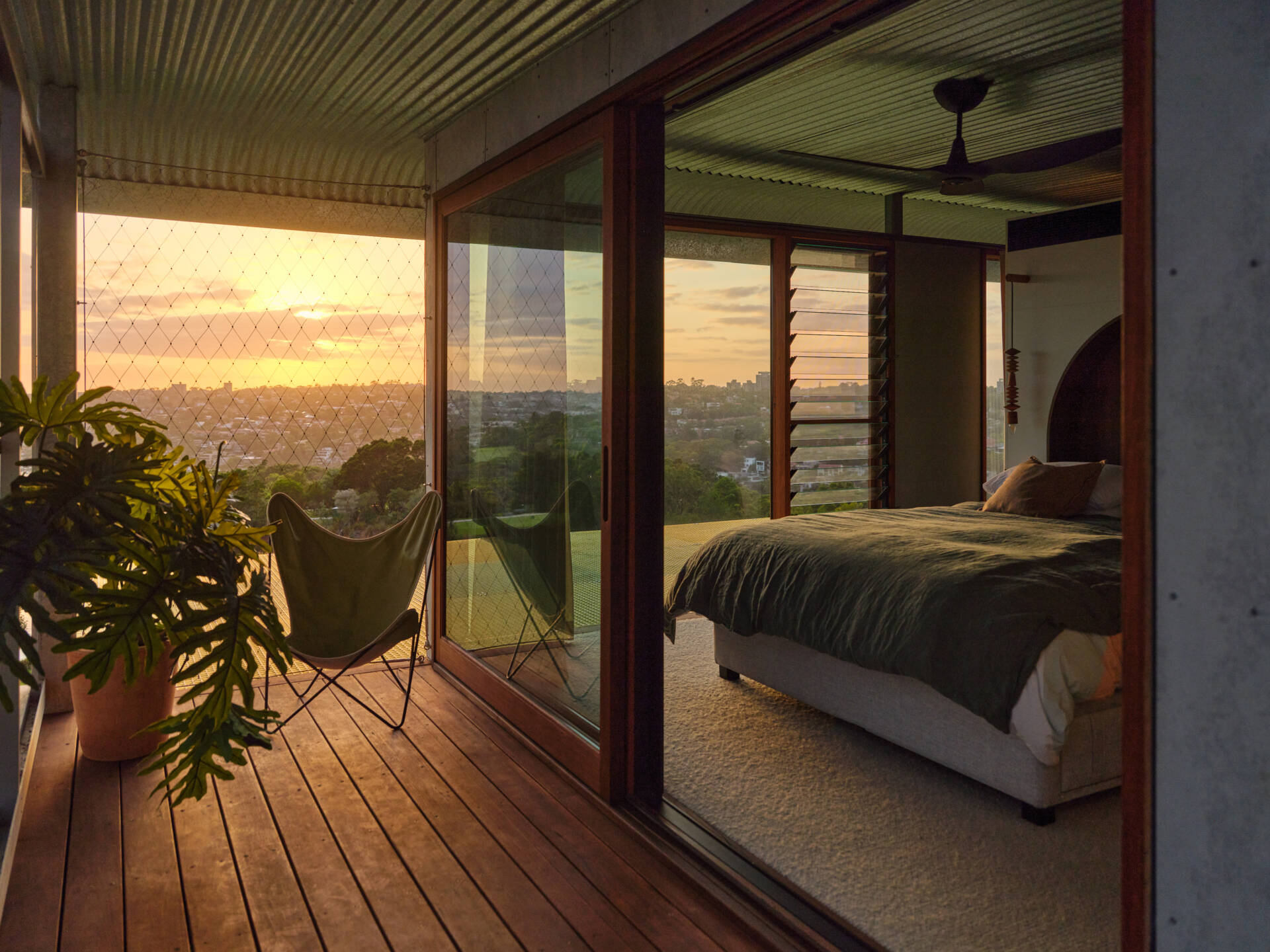A stunning primary bedroom with sweeping views across Sydney’s harbour landscape.