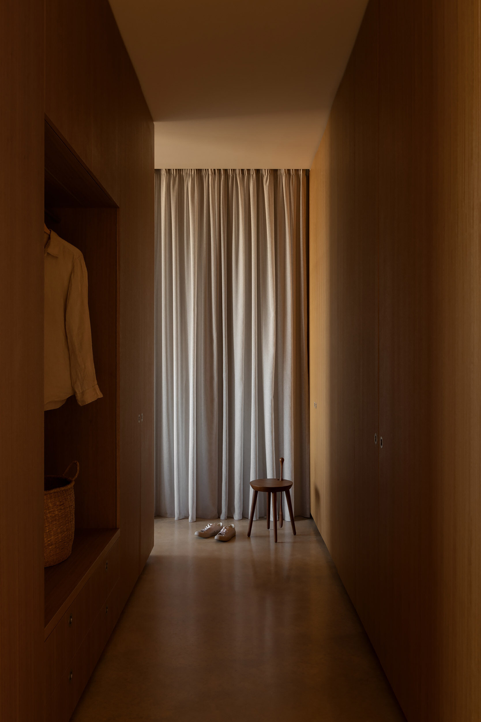 A dressing area continues the home's restrained approach, providing generous storage while maintaining clean lines and minimal visual clutter.