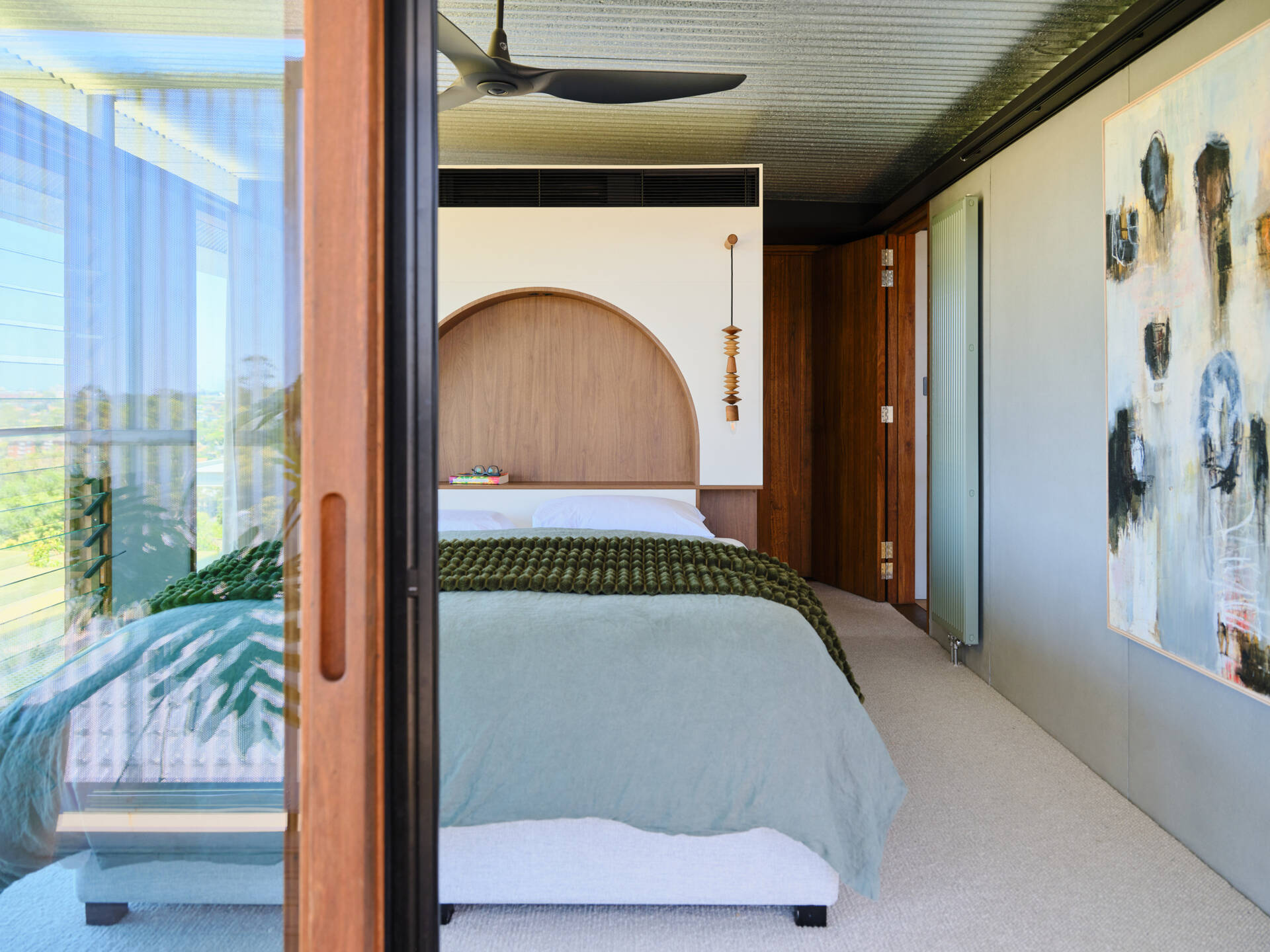 A stunning primary bedroom with sweeping views across Sydney’s harbour landscape.