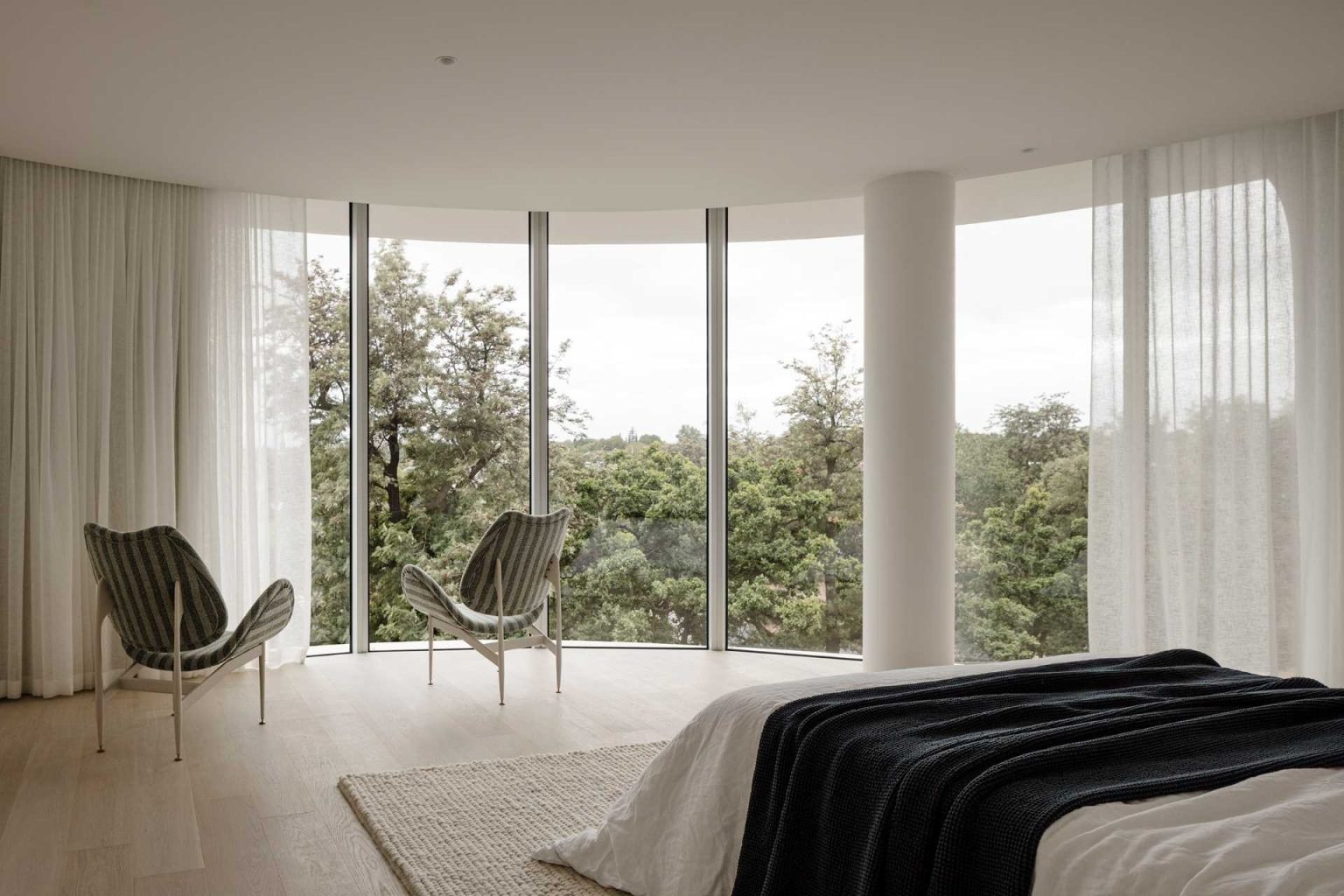 Soft curtains, natural light, and elegant finishes create tranquil bedrooms that echo the flowing forms found throughout No. 6 Sydney Street.