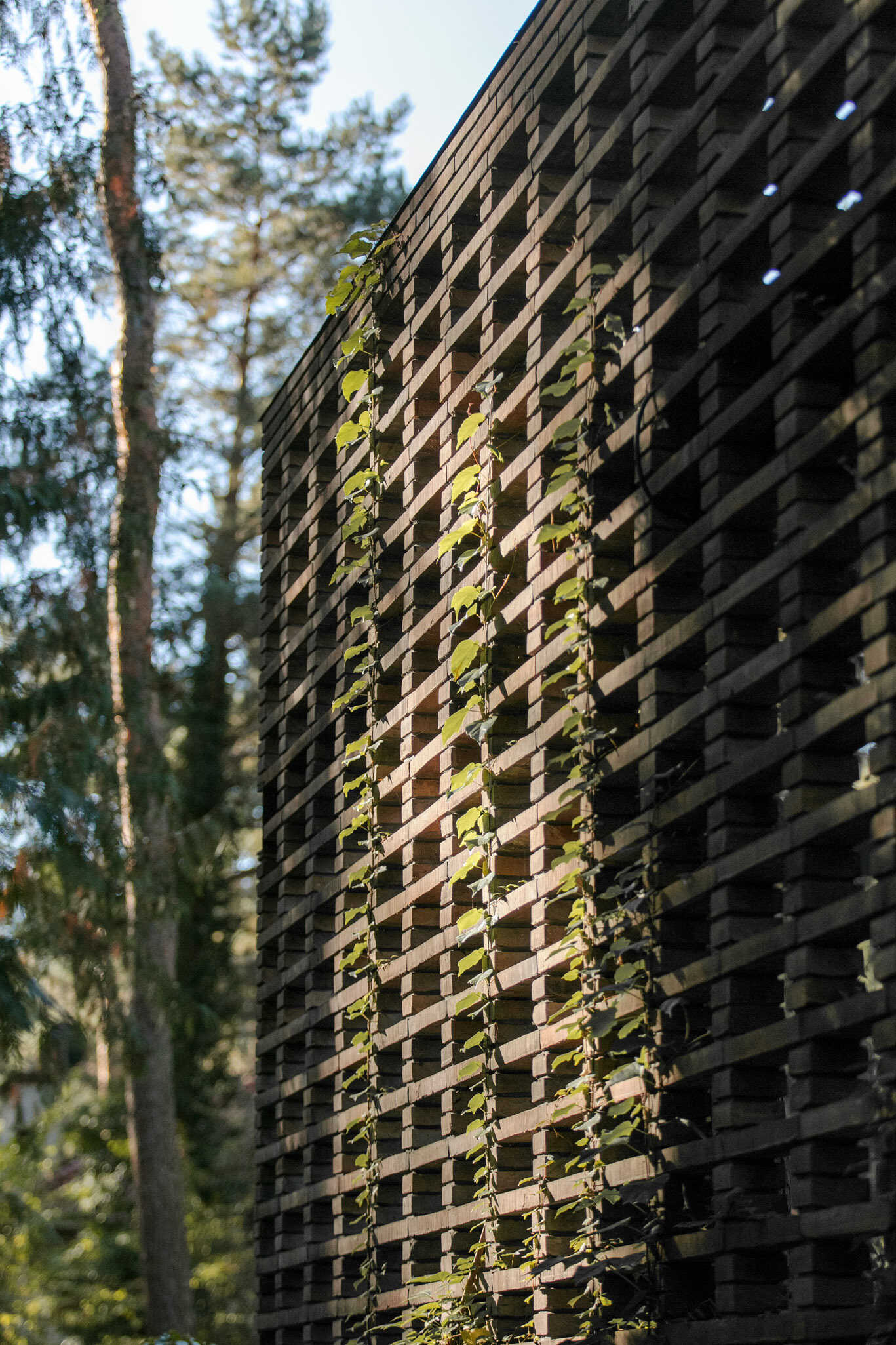 Hand-formed brickwork gives House with a Glade warmth and texture. Inspired by the bark of surrounding pine trees, the façade includes openwork sections that filter light and conceal private outdoor spaces.