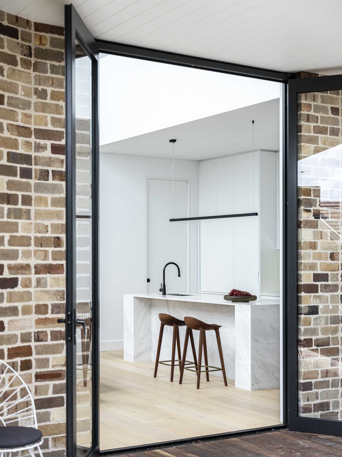 Recycled bricks, dramatic angles, and black-framed windows give this Sydney extension a bold architectural identity.