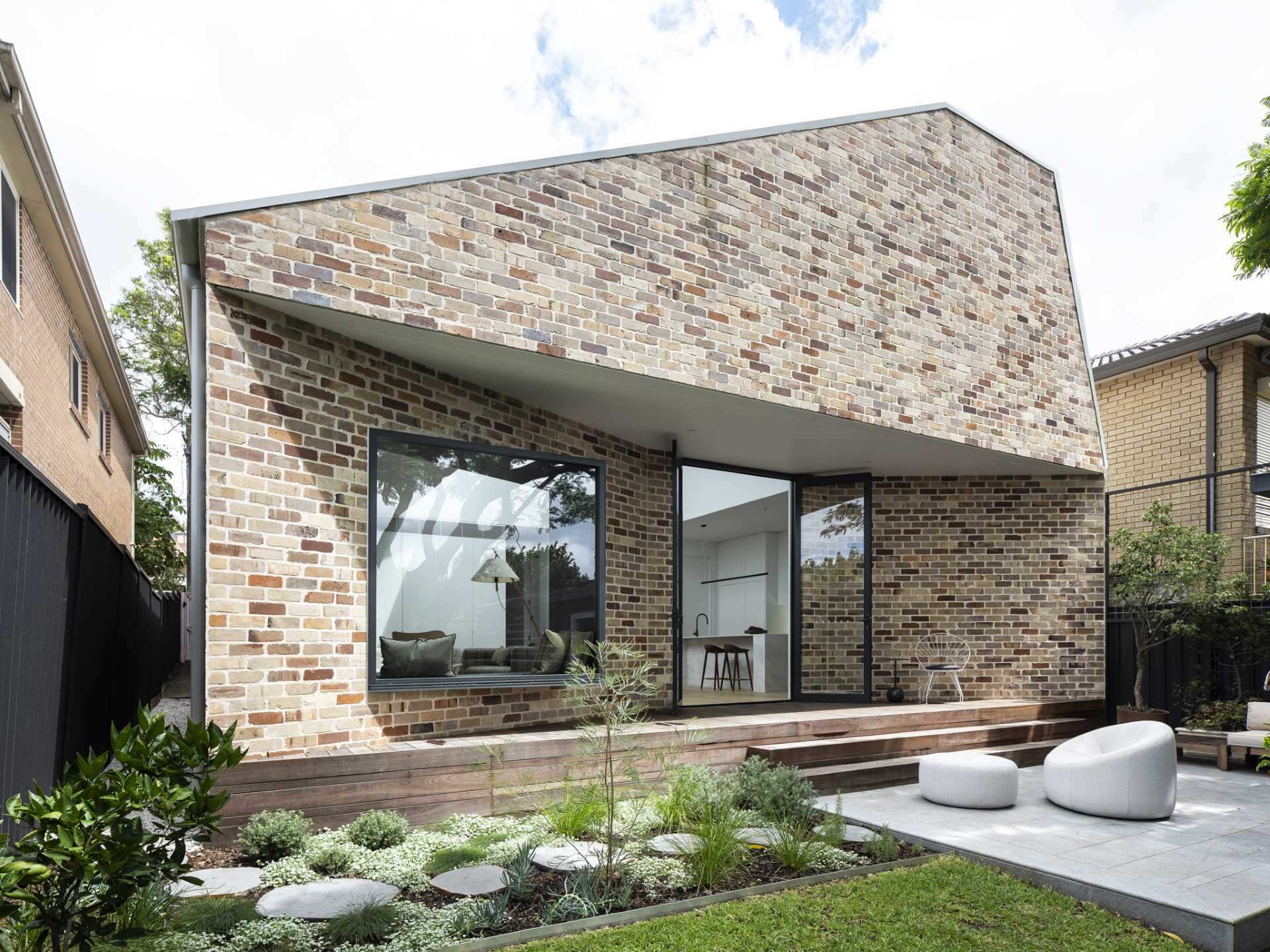 Recycled bricks, dramatic angles, and black-framed windows give this Sydney extension a bold architectural identity.