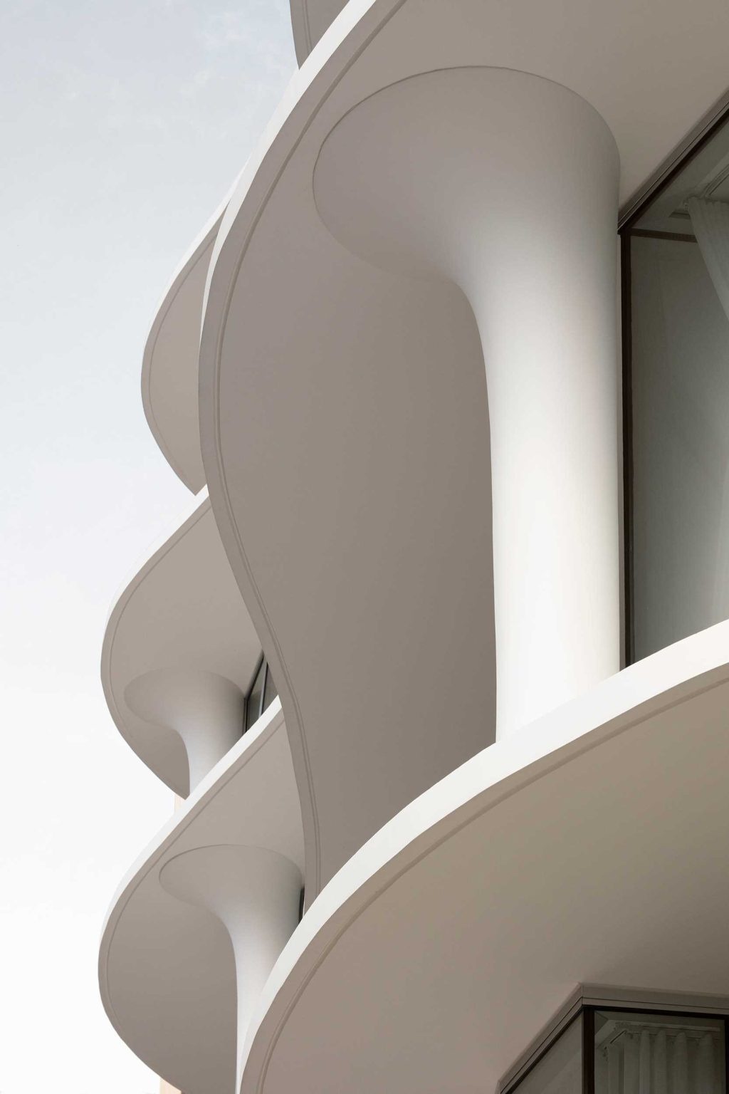 Organic curves, rippling facades, and sculpted flared columns give No. 6 Sydney Street its unique architectural identity. A striking example of contemporary residential design by Wood Marsh.