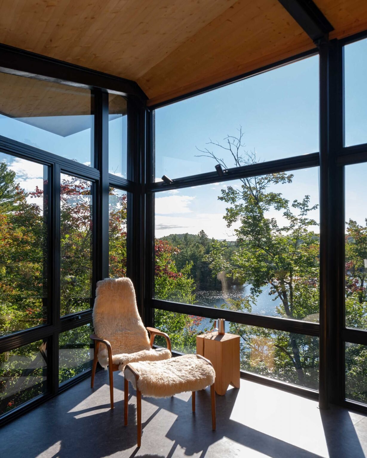 Warm timber interiors and floor-to-ceiling windows bring forest views into every corner of this modern Quebec cabin.