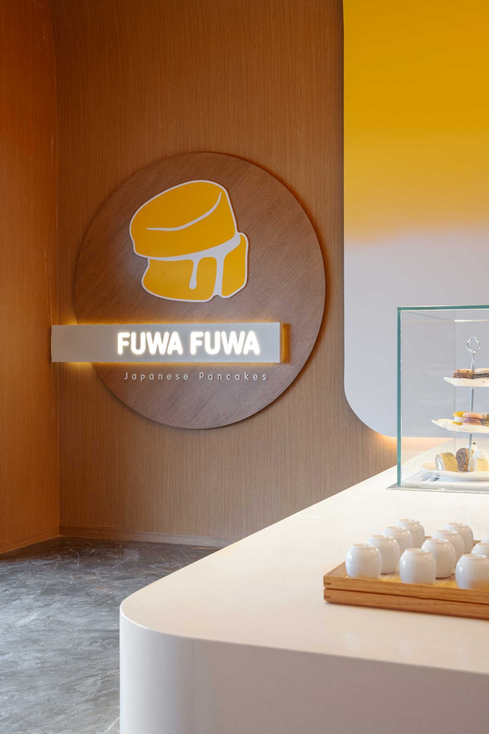 A soaring yellow ceiling and temple-inspired service area create a striking focal point inside Fuwa Fuwa Golden Square, showcasing Studio Yimu's bold approach to cafe design.