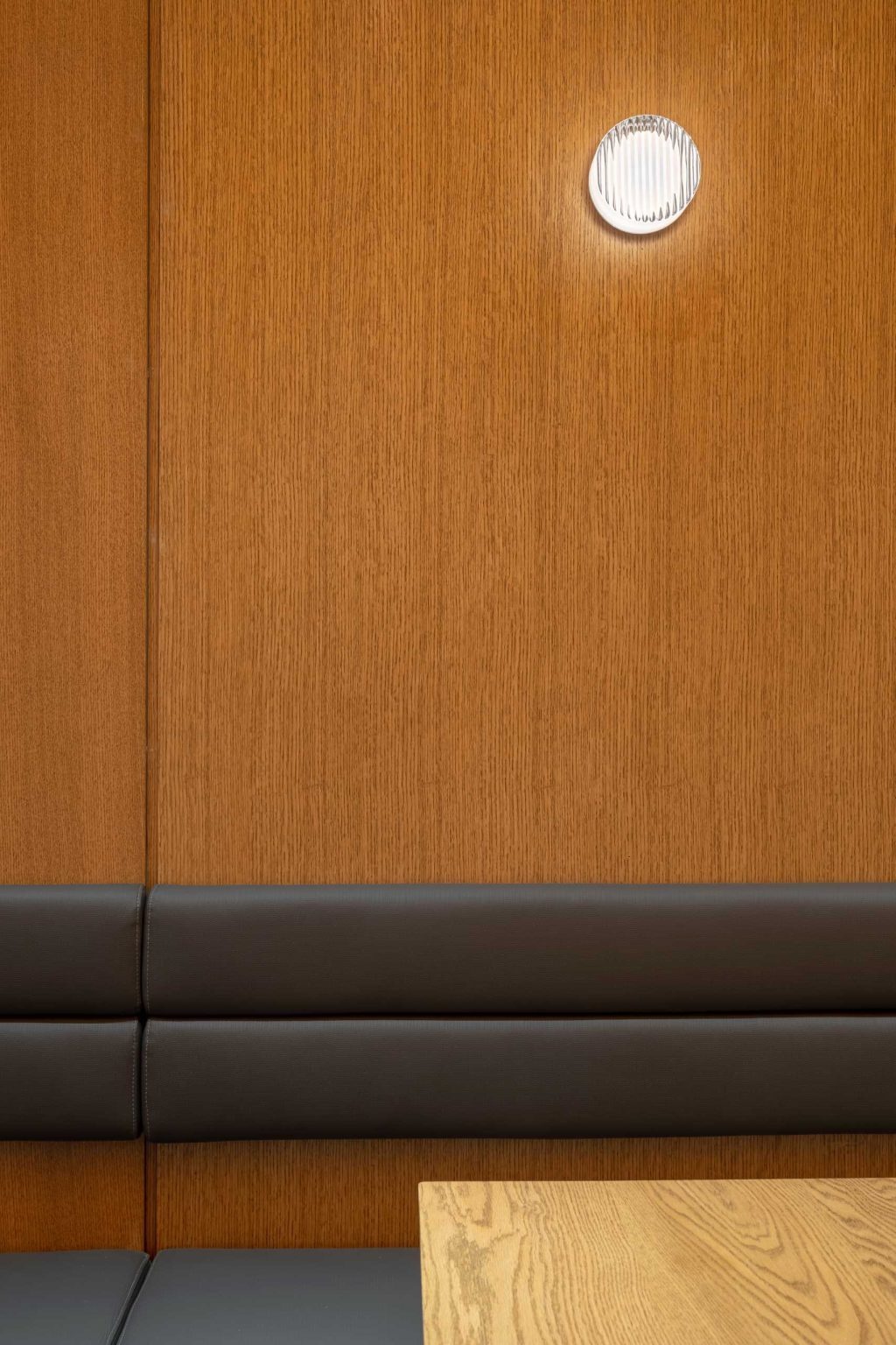 An inviting alcove with banquette seating, wood tables, and warm materials offers a comfortable dining experience within Fuwa Fuwa Golden Square.