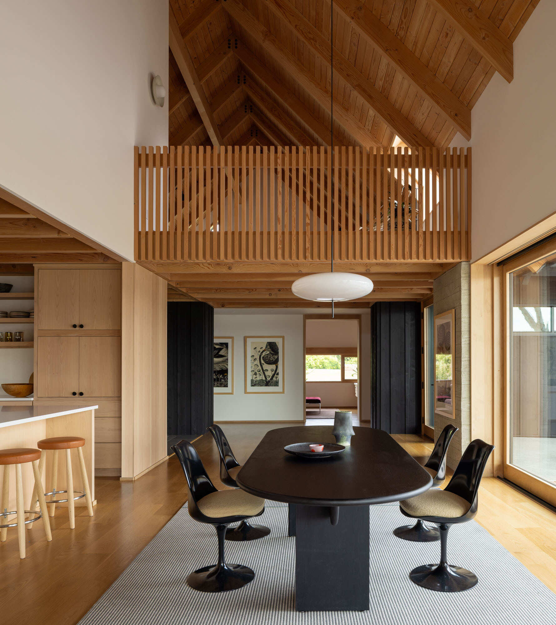 This dining area pairs warm natural materials with beautiful views across the patio and waterfront landscape.