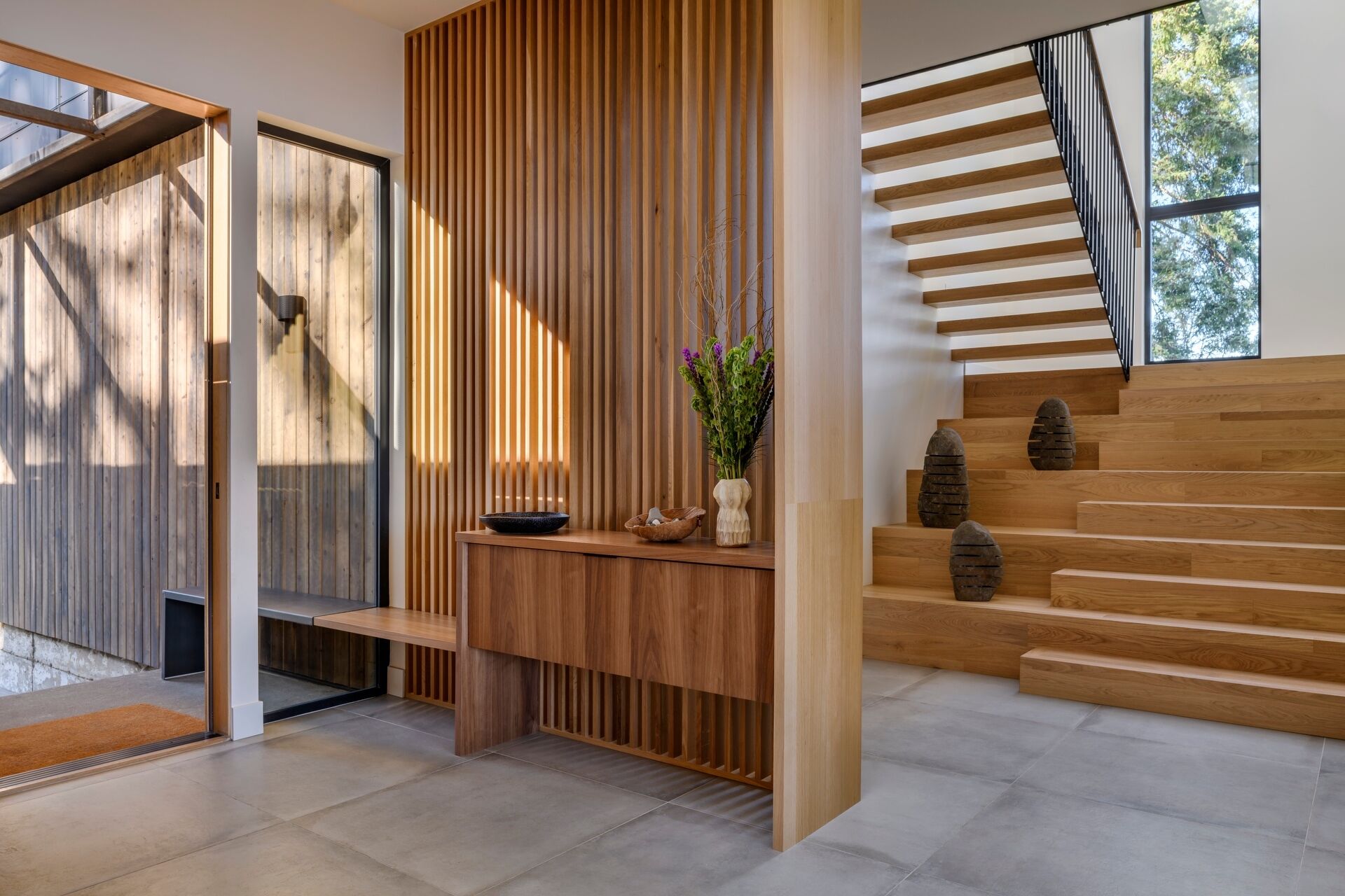 Step inside Lantern House through a light-filled entry featuring warm timber battens, a floating staircase, and beautiful modern Pacific Northwest design.