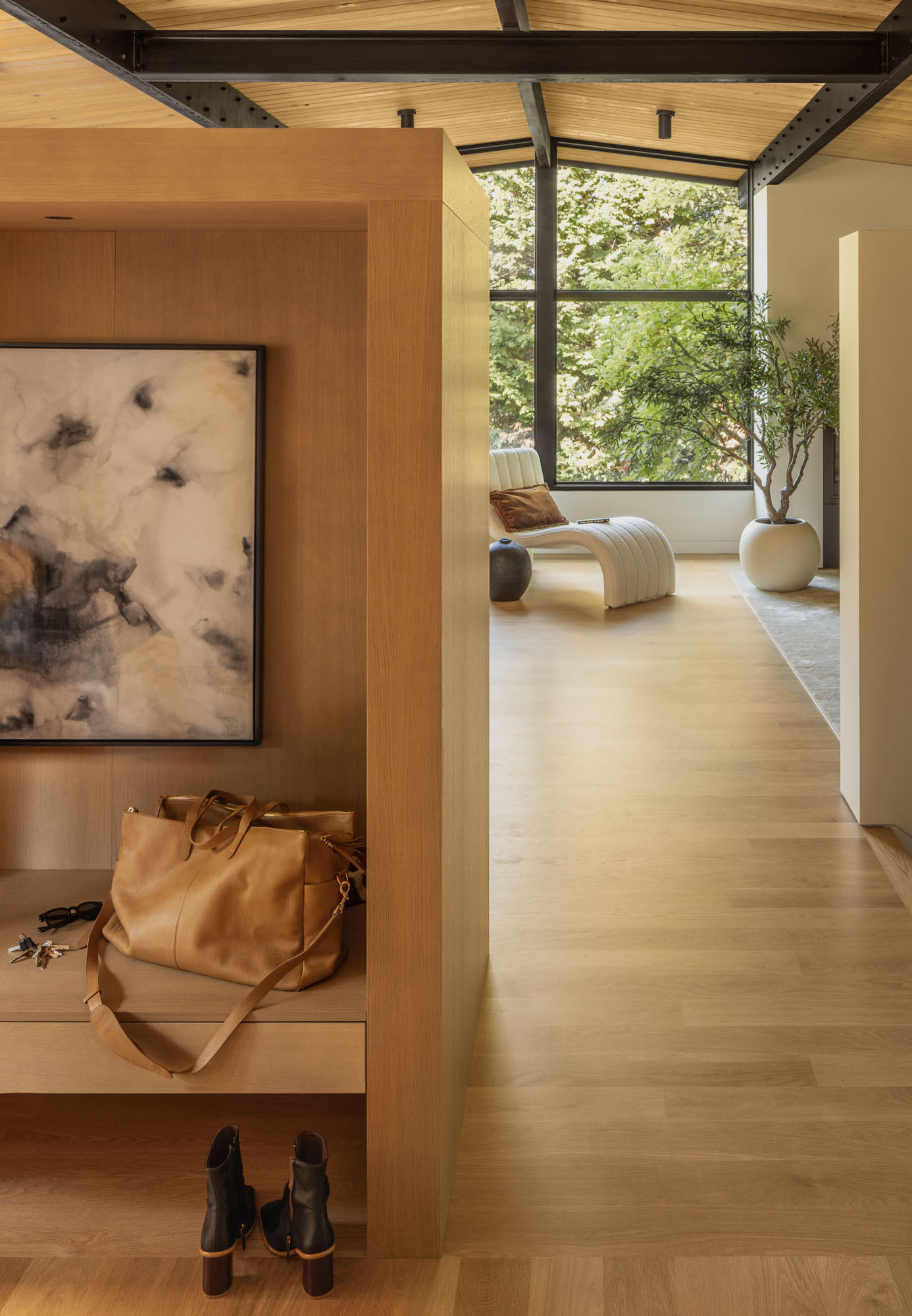 The entryway at Island Crest pairs custom white oak storage with open views into the living spaces beyond. It's a functional welcome that balances everyday practicality with bright, open interiors.