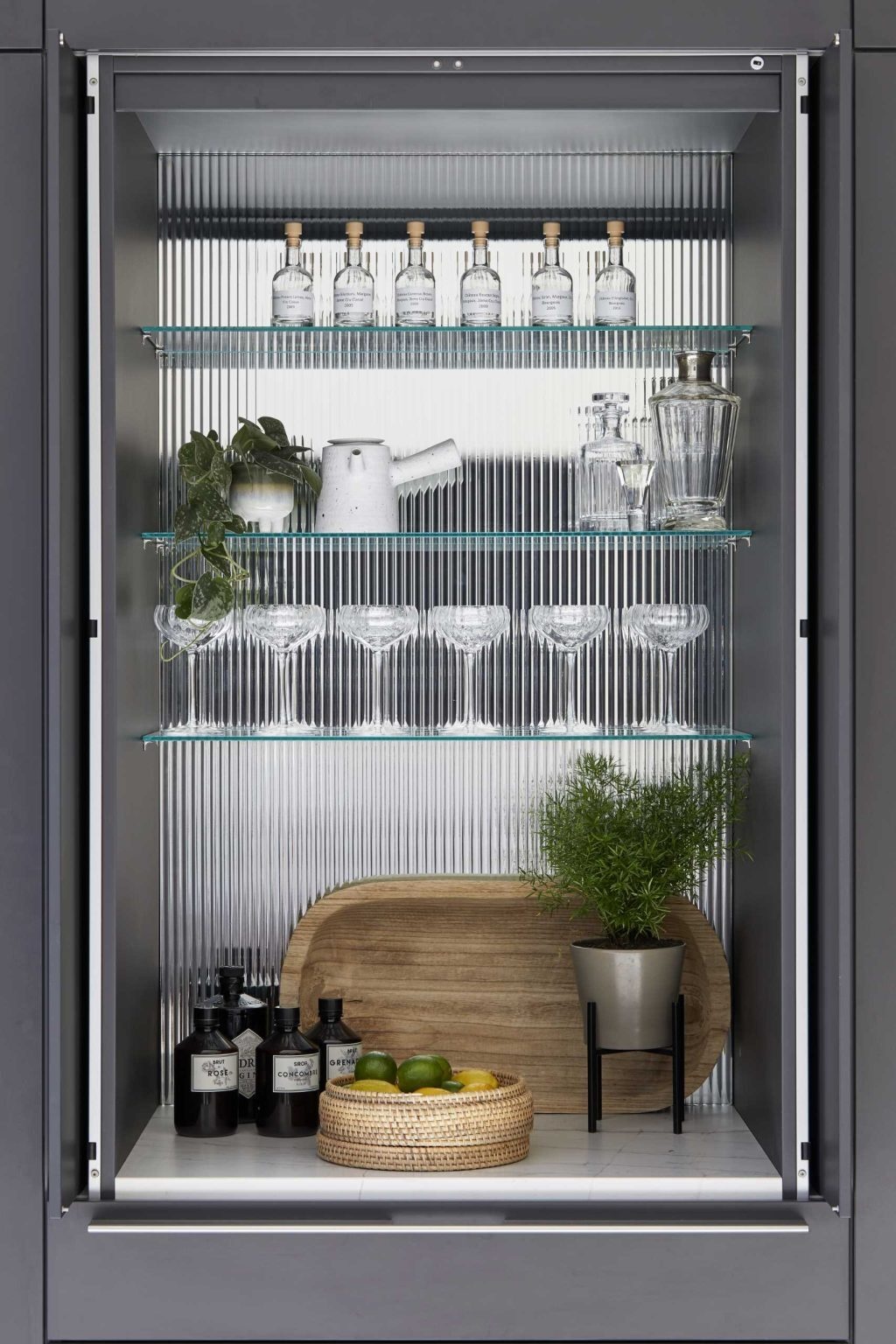 Matte black cabinetry, a crisp white island, and a hidden bar make this contemporary kitchen both stylish and practical.