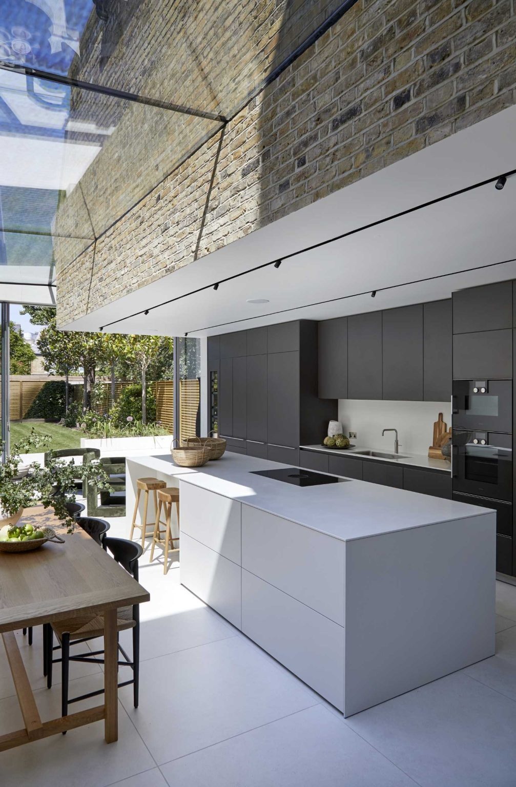 Matte black cabinetry, a crisp white island, and a hidden bar make this contemporary kitchen both stylish and practical.