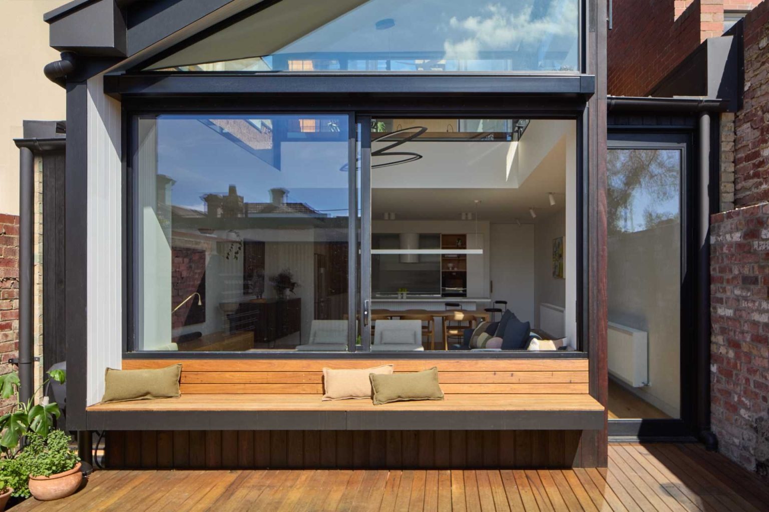 A built-in bench beneath a large sliding window creates the perfect spot to enjoy the courtyard while connecting indoor and outdoor living.