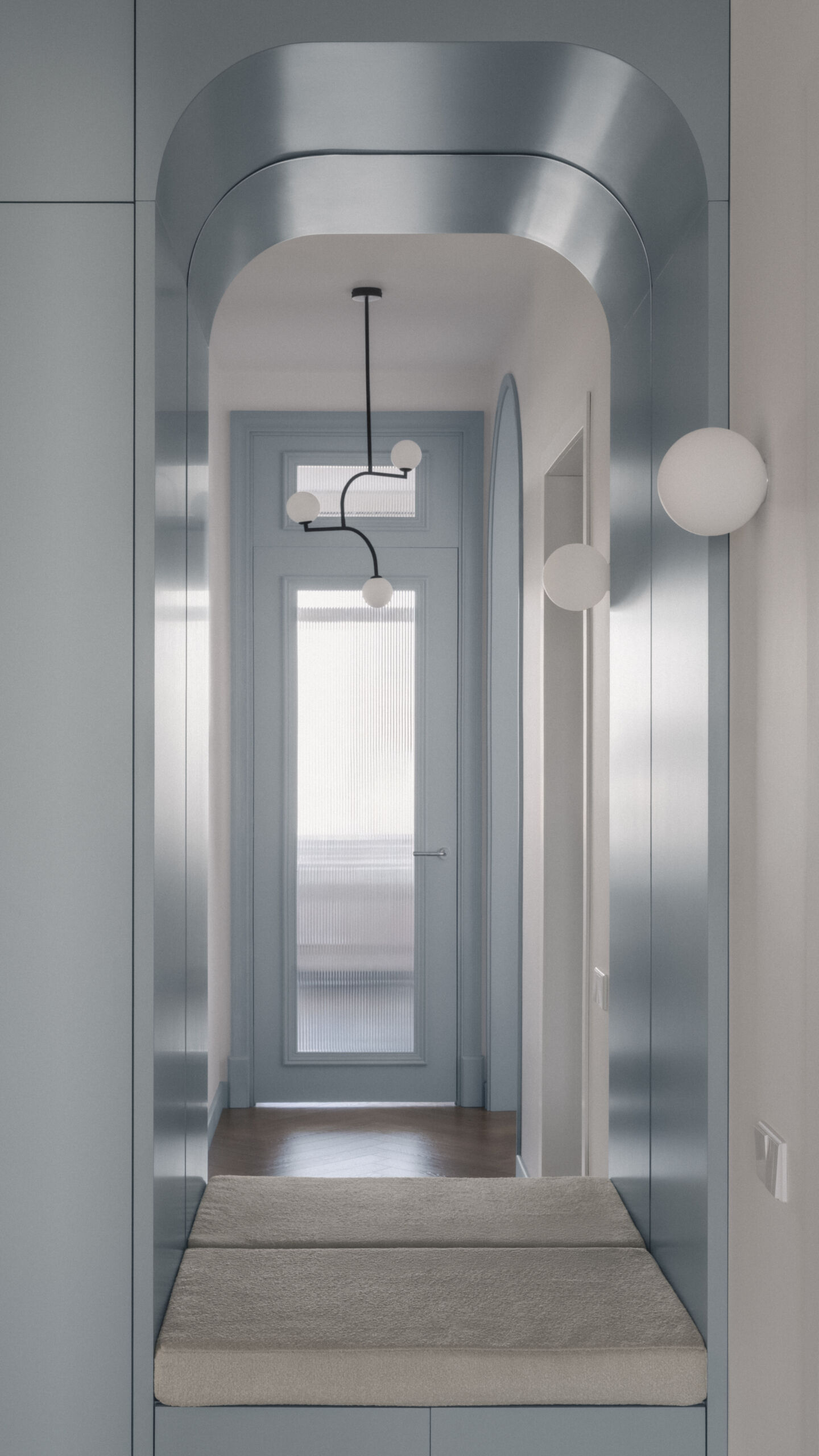 The experience begins in an entryway that immediately introduces the apartment's soft palette. Light finishes help maximize brightness while creating an inviting first impression, and built-in elements provide plenty of storage.
