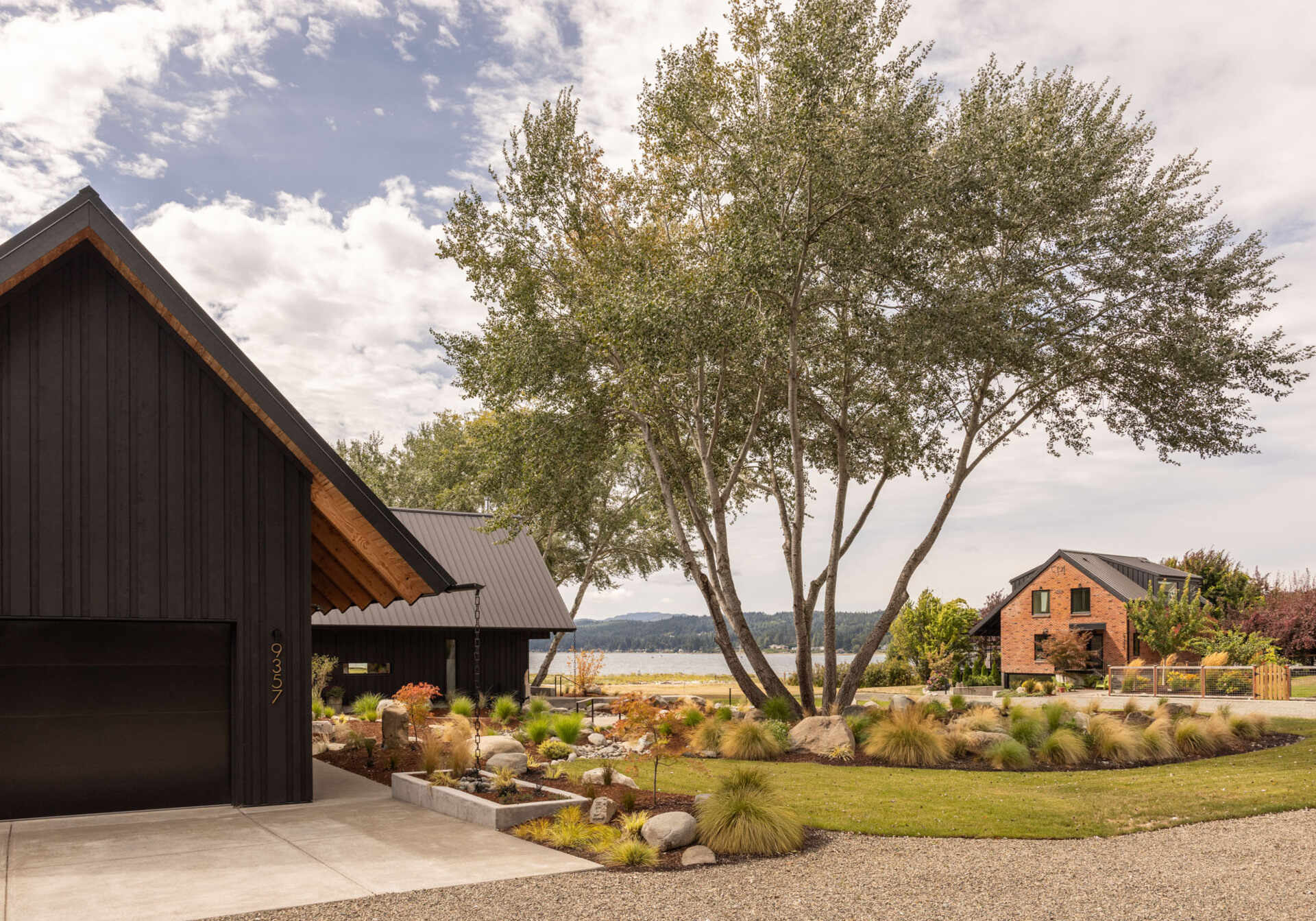 A Scandinavian-inspired waterfront home in Silverdale, Washington combines intersecting gabled forms, vaulted ceilings, and stunning views across Dyes Inlet.