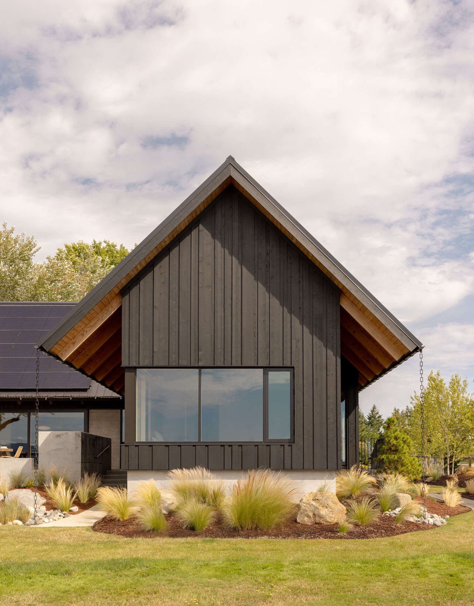 A Scandinavian-inspired waterfront home in Silverdale, Washington combines intersecting gabled forms, vaulted ceilings, and stunning views across Dyes Inlet.