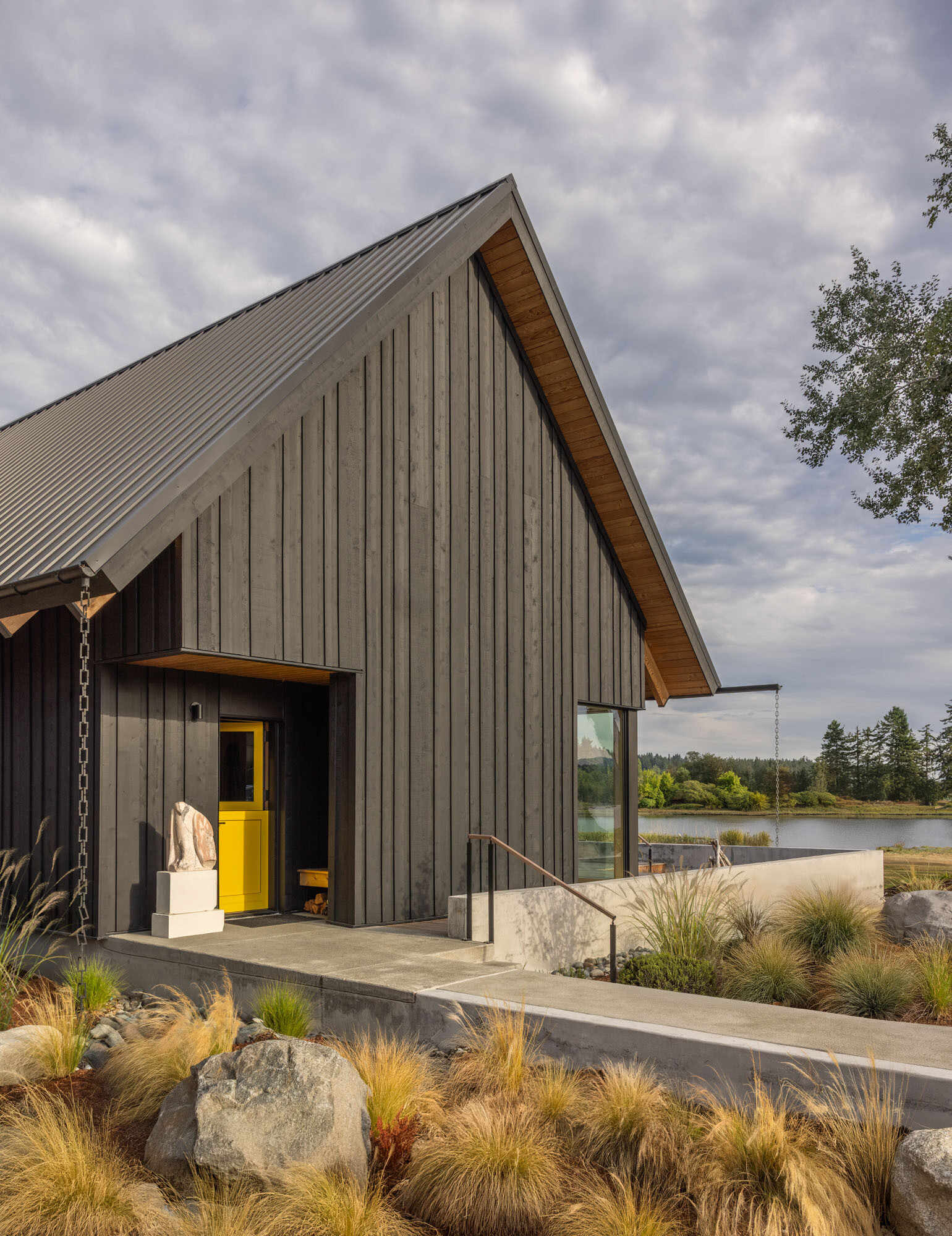 A Scandinavian-inspired waterfront home in Silverdale, Washington combines intersecting gabled forms, vaulted ceilings, and stunning views across Dyes Inlet.