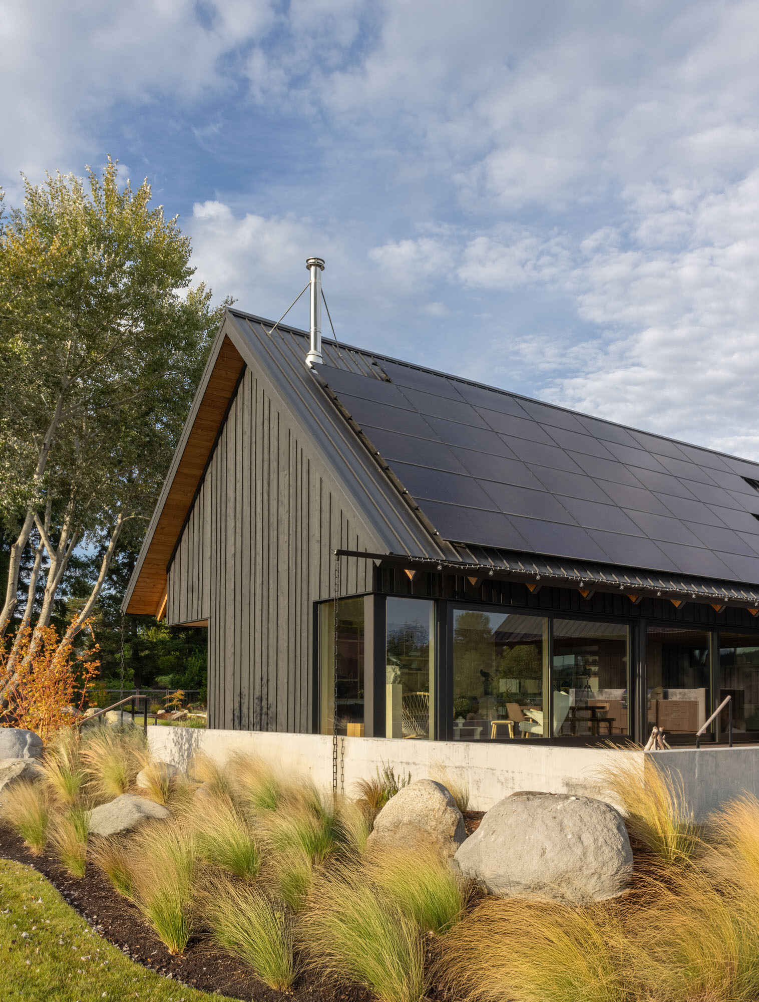 A Scandinavian-inspired waterfront home in Silverdale, Washington combines intersecting gabled forms, vaulted ceilings, and stunning views across Dyes Inlet.
