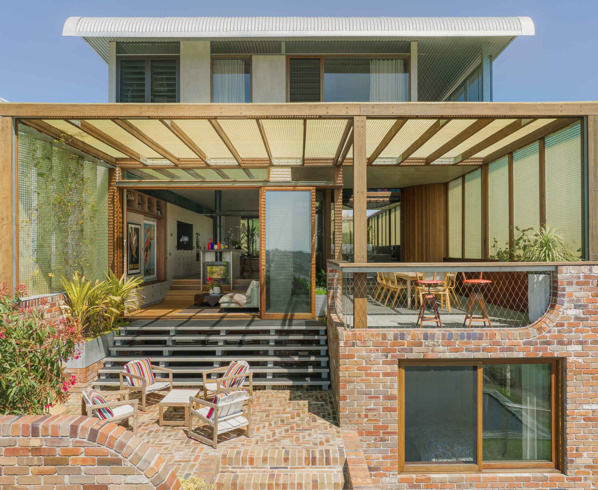 The rear of Terabithia House showcases layered terraces, expansive glazing, and breathtaking views across Sydney Harbour.