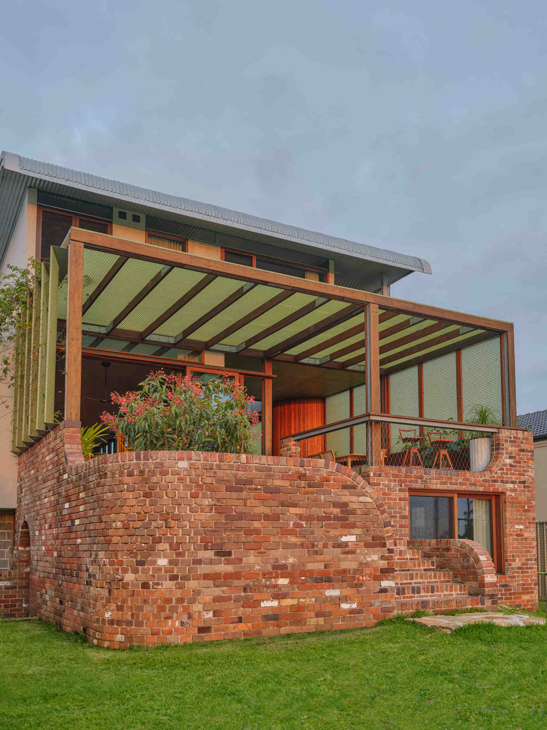 The rear of Terabithia House showcases layered terraces, expansive glazing, and breathtaking views across Sydney Harbour.