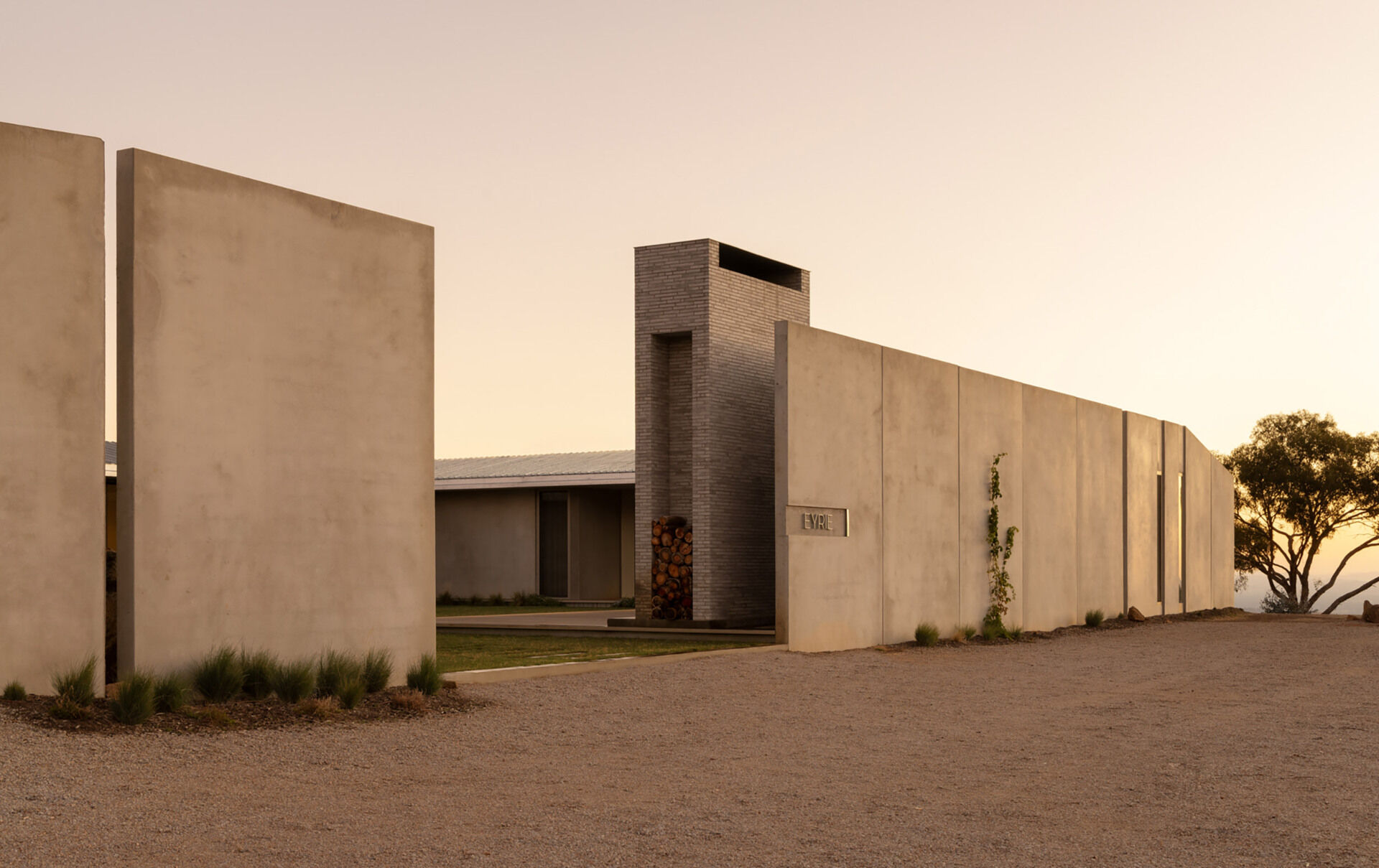 Hidden behind a concrete wall, the arrival experience at Eyrie Residence creates a dramatic reveal as visitors discover the courtyard beyond.