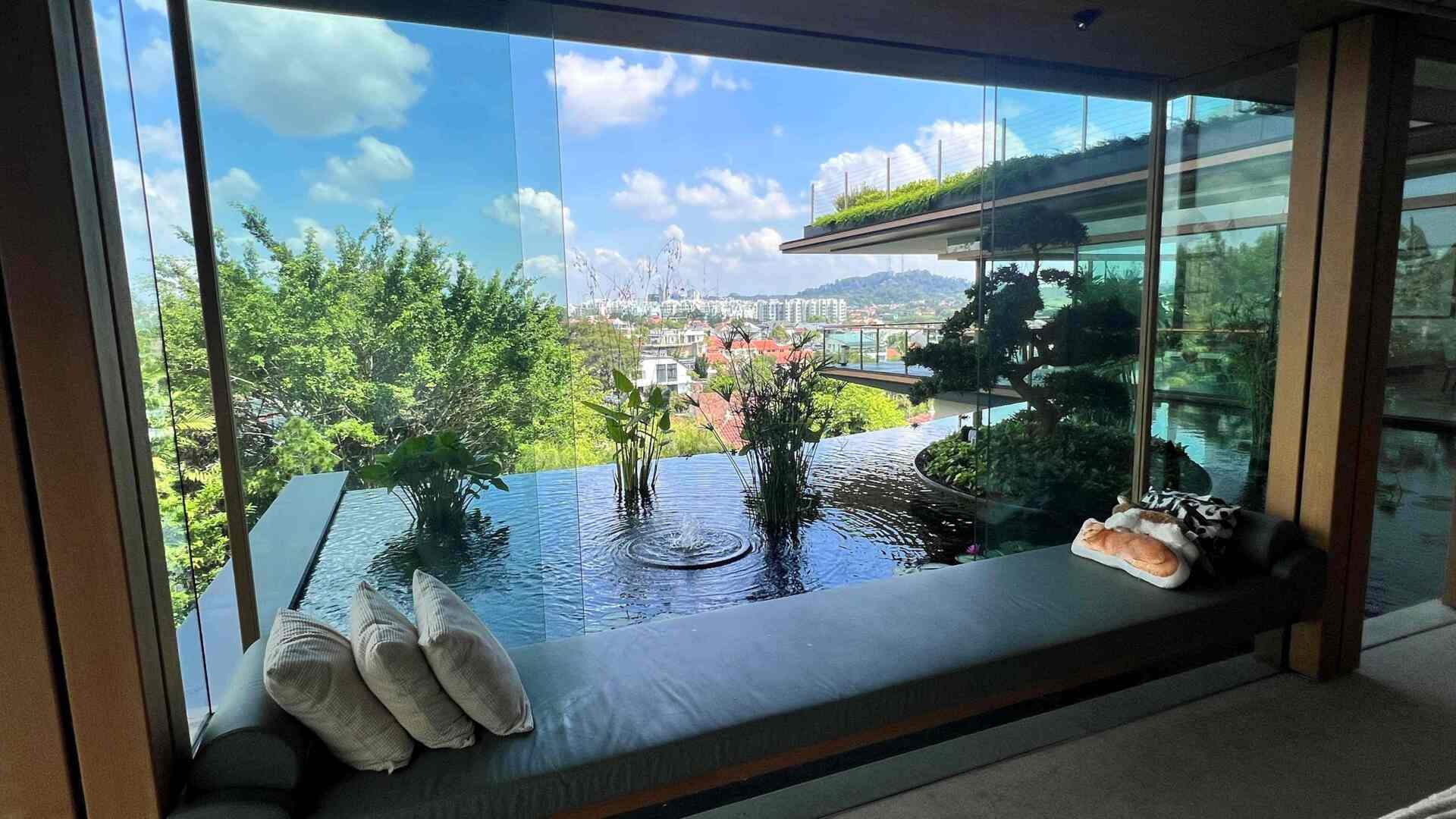 A multi-generational home filled with terraced gardens, rooftop lawns, reflecting ponds, and breathtaking city views. Warm timber interiors, tropical landscaping, open-air walkways, and a lagoon-like pool create a beautiful blend of architecture and nature.