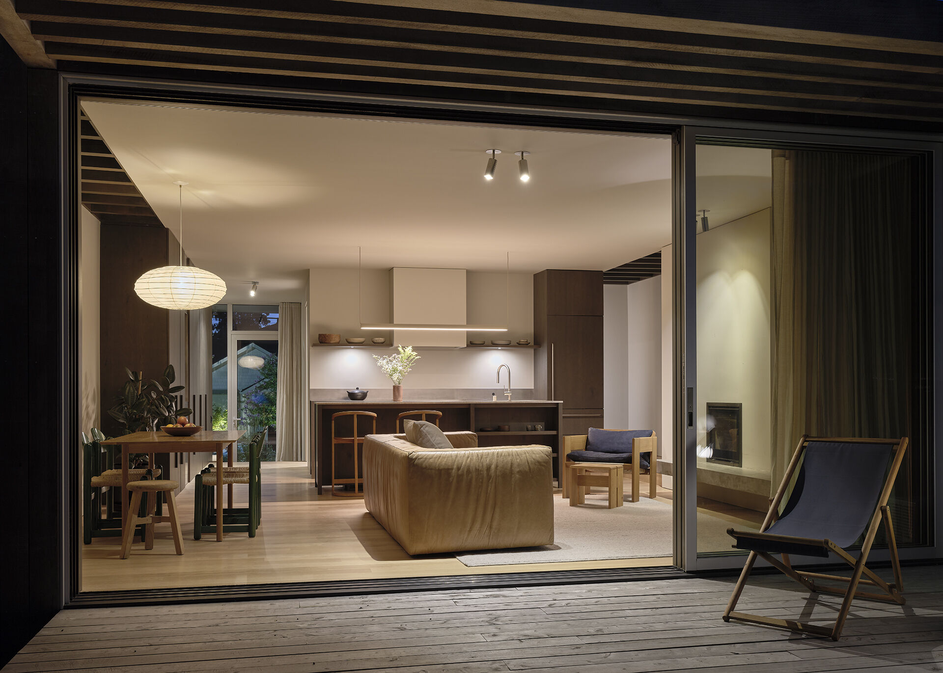 A garden-facing deck extends the living and dining areas, bringing indoor and outdoor spaces together.